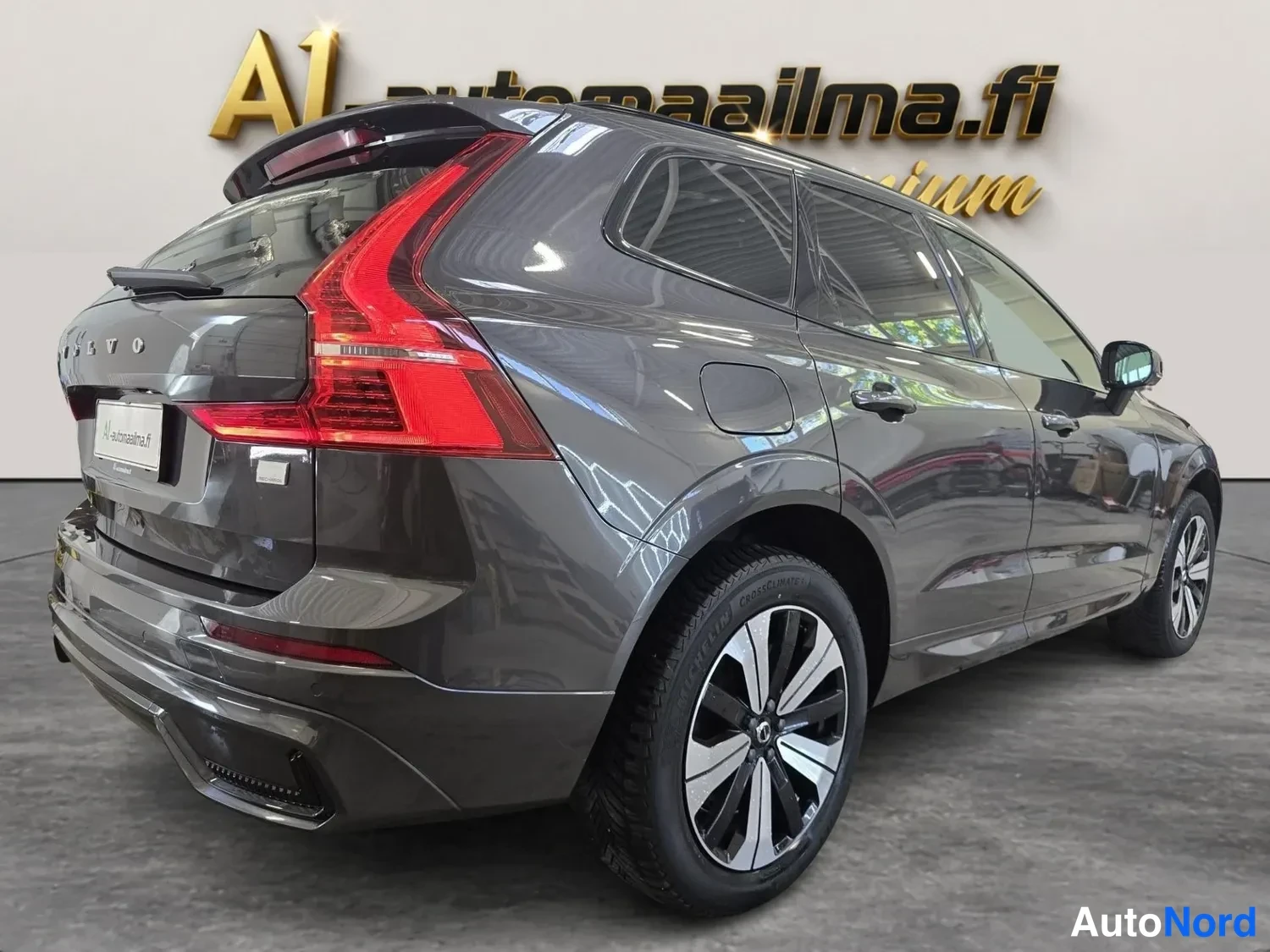 Takaviisto: Volvo XC60 taka­viistosta oikealta kuvattuna tummanharmaana; punaiset LED-takavalot, kattokaiteet ja muovinen pakopuskuri näkyvät.