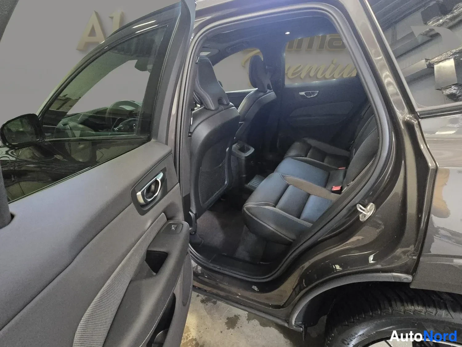 Muu: Volvo XC60:n takapenkki oven takaa: mustat istuimet ja takapenkki näkyvät auton sisältä.