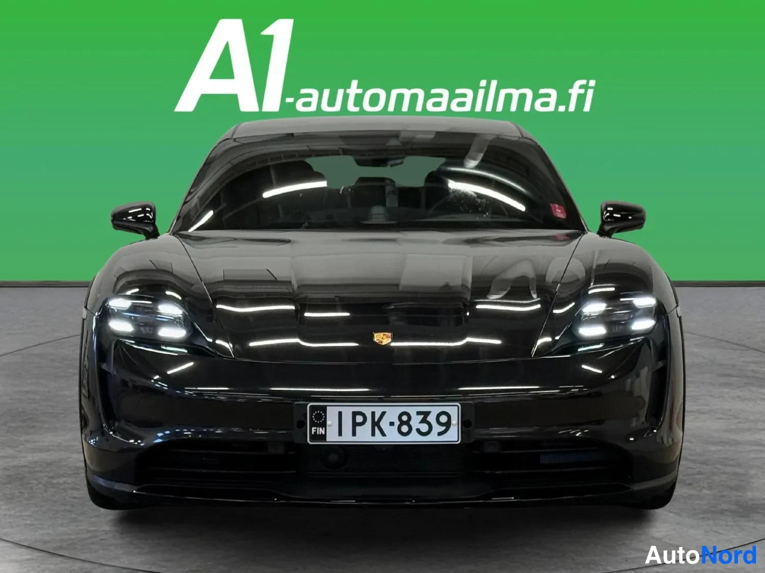 Edestä: Mustan Porsche Taycanin etunäkymä, rekisteritunnus.