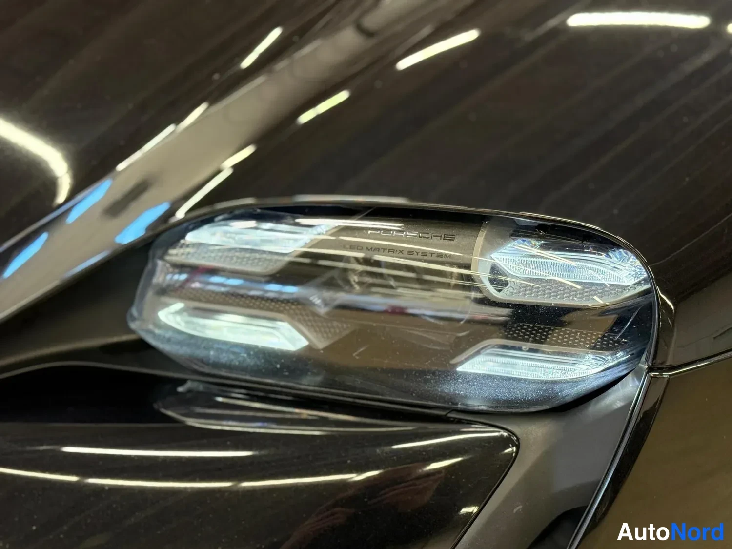Edestä: Lähikuva mustan auton etuvalosta; lasissa lukee Porsche LED Matrix System.