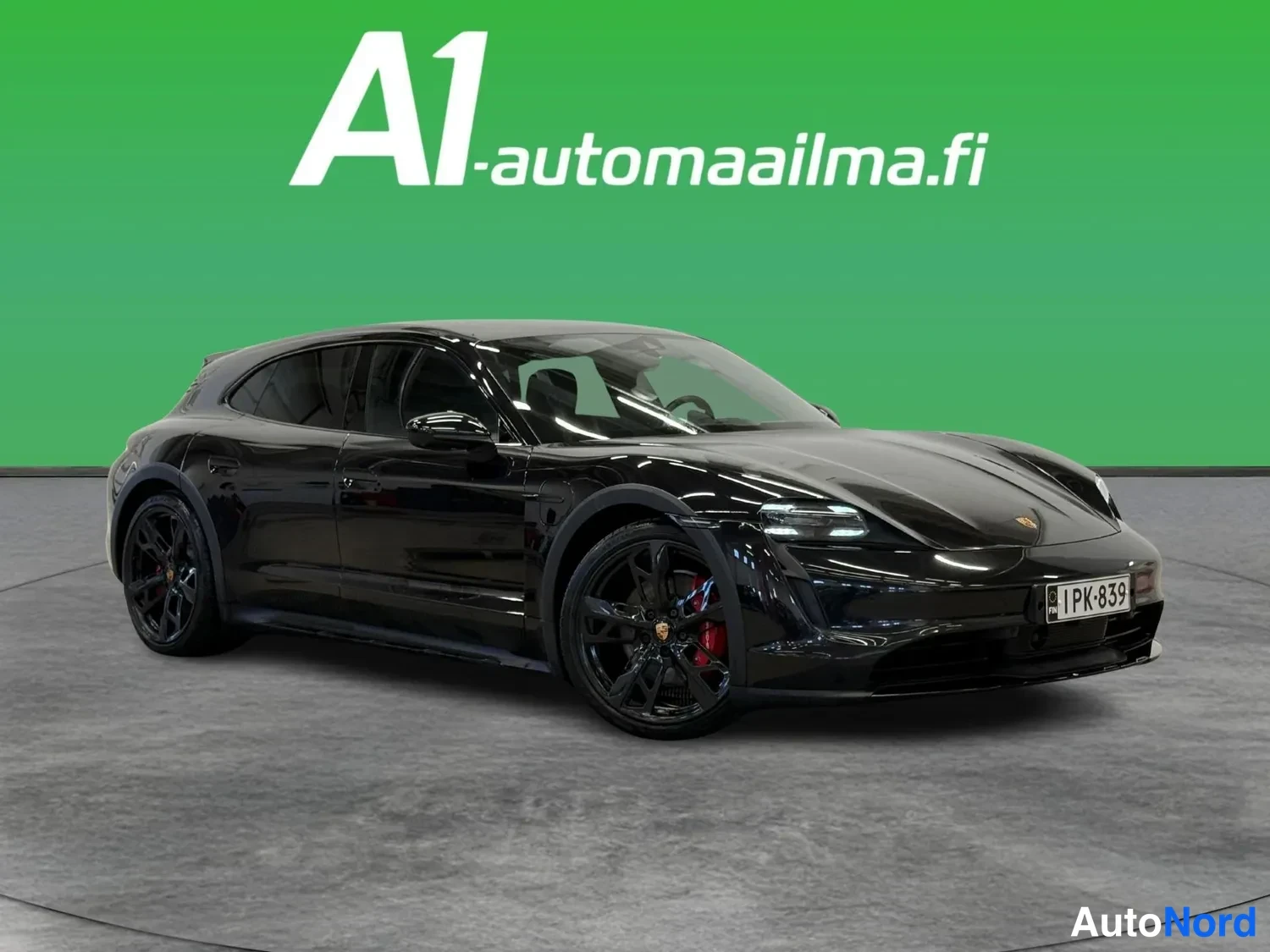 Etuviisto, nokka oikealle: Musta Porsche Taycan Sport Turismo kolmesta neljännesnäkymästä edestä oikealta, rekisterissä.