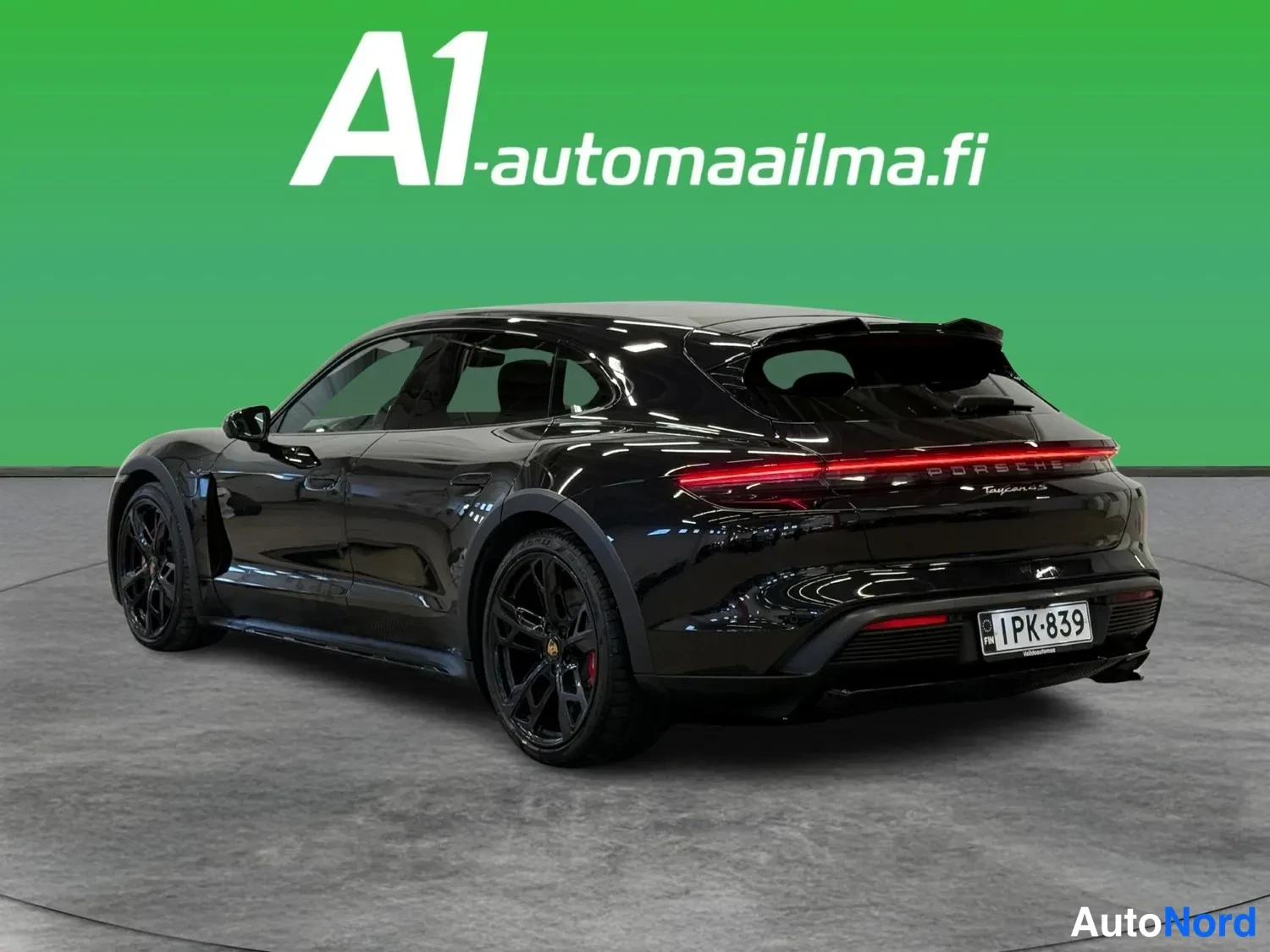 Takaviisto: Mustan Porsche Taycanin takakolmannesnäkymä vasemmalta, takavalo ja rekisteritunnus.