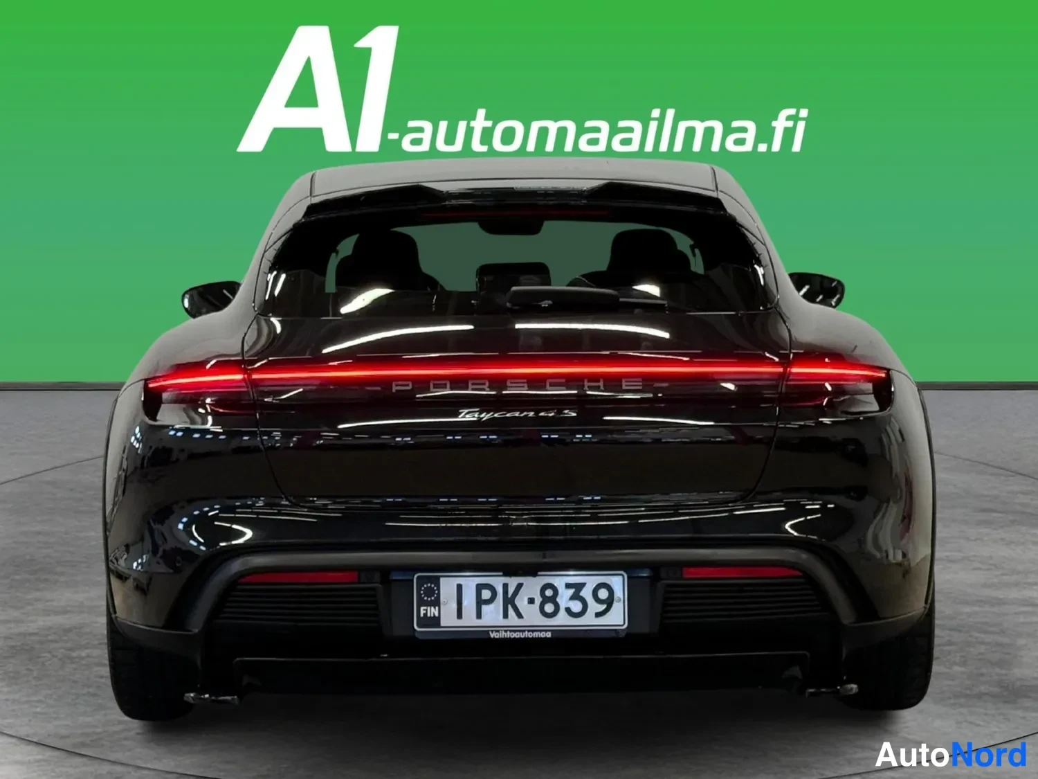 Takaa: Musta Porsche Taycan Cross Turismo takaa kuvattuna; vyöhykejarruvalot päällä, rekisterikilpi.