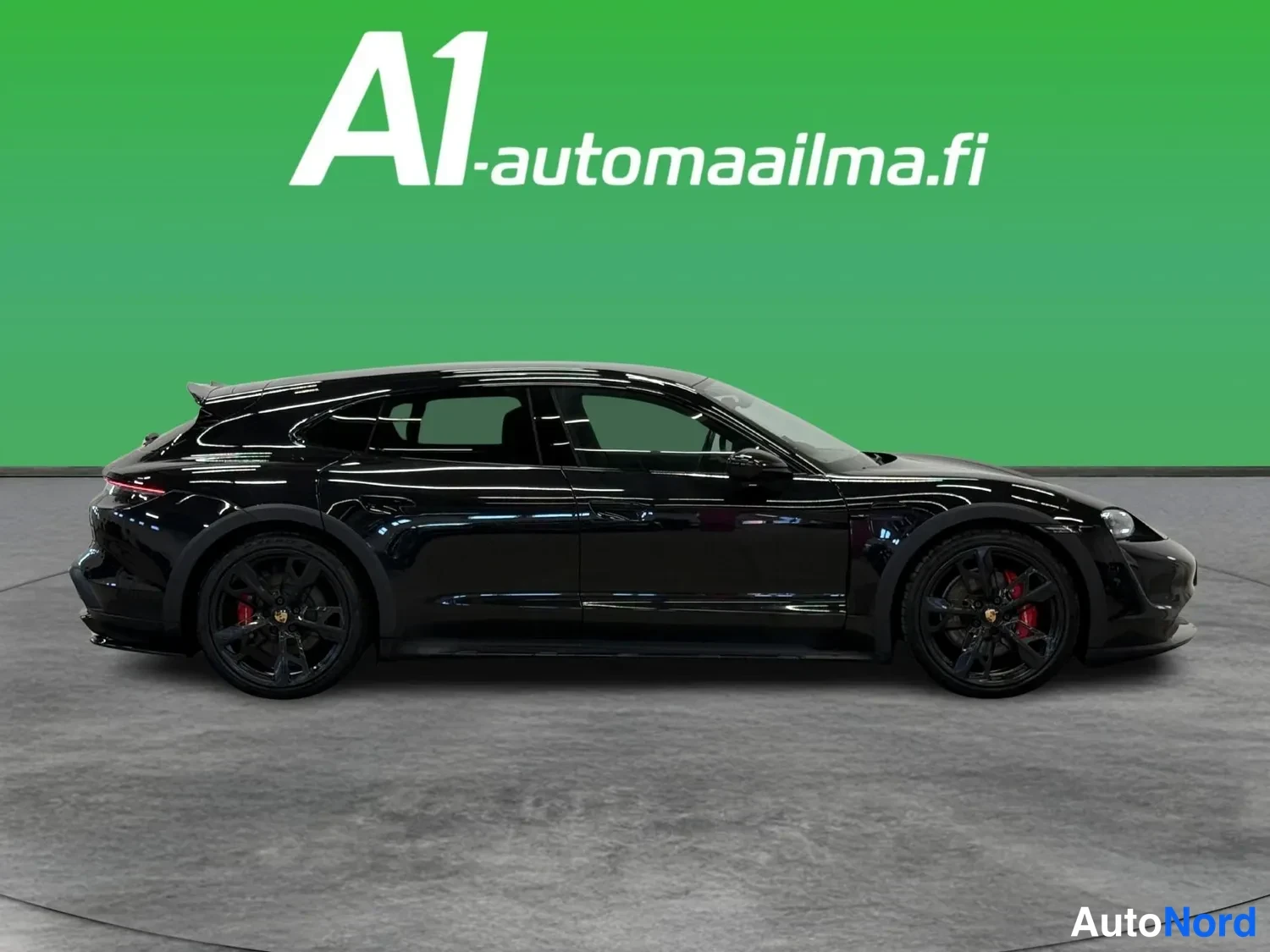 Sivulta: Musta Porsche Taycan Cross Turismo sivulta oikealta; tummat vanteet ja punaiset jarrusatulat näkyvät.