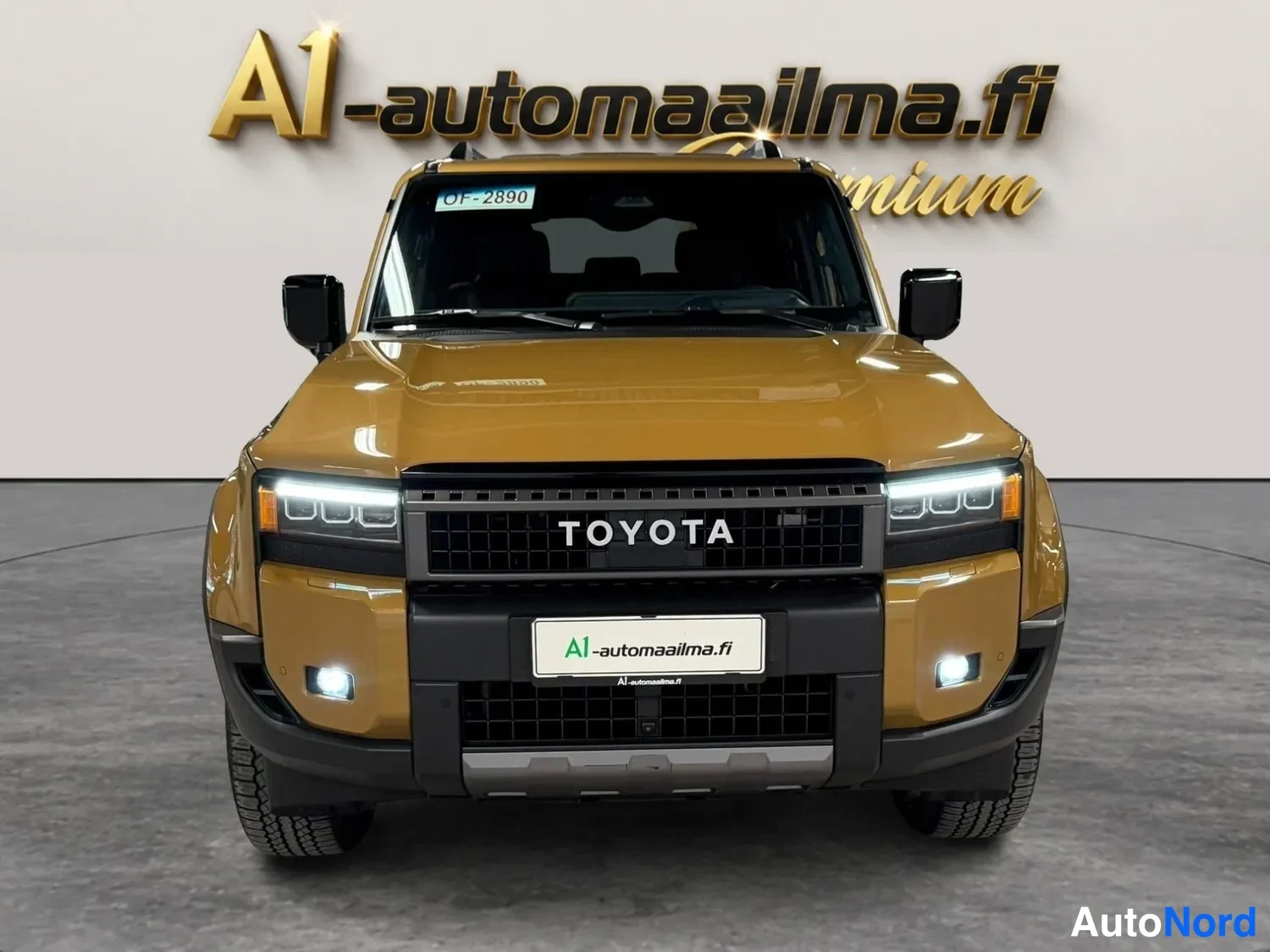 Edestä: Kullankeltaisen Toyota Land Cruiserin etupää kuvattuna suoraan edestä, TOYOTA-teksti jäähdyttäjän säleistössä.