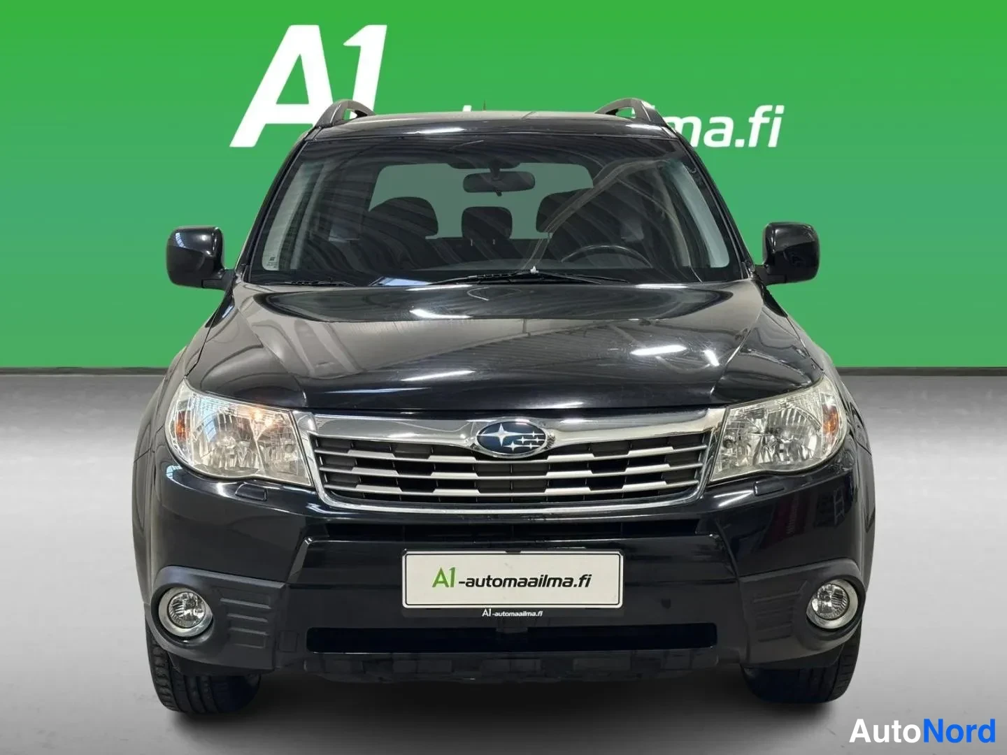 Edestä: Musta Subaru Forester suoraan edestä valaistuna, etusäleikkö ja sumuvalot näkyvissä.