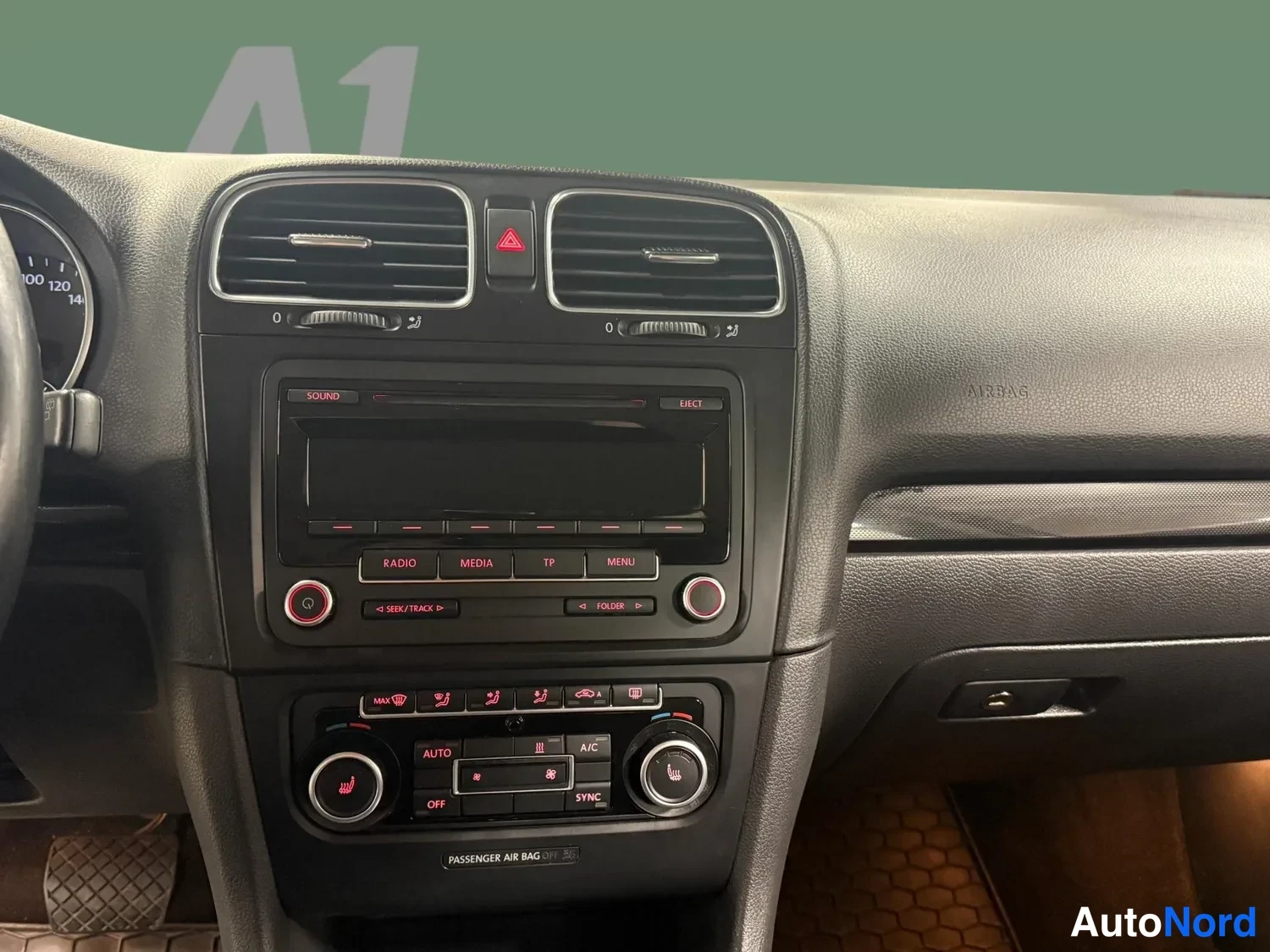Edestä: Kojelaudan keskiosa: radiopaneeli ja automaattinen ilmastointi, painikkeet RADIO, MEDIA, TP, MENU, AUTO, A/C ja SYNC näkyvät.