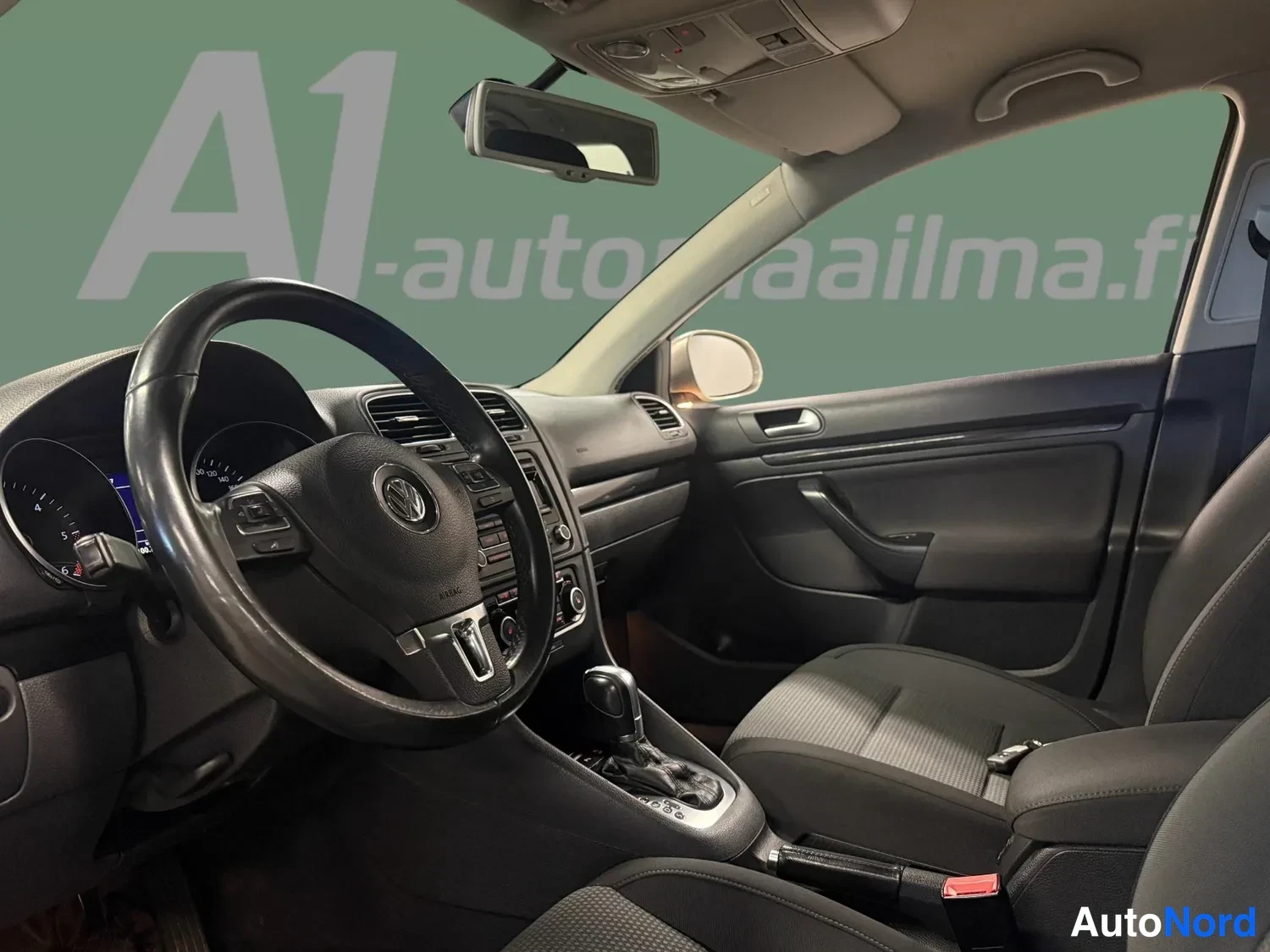 Muu: Ohjaamo kuljettajan näkökulmasta: Volkswagen-merkitty ohjauspyörä, mittaristo, keskikäyttöpaneeli, DSG-automaattivaihteiston vaihteenvalitsin ja tumma kangasver