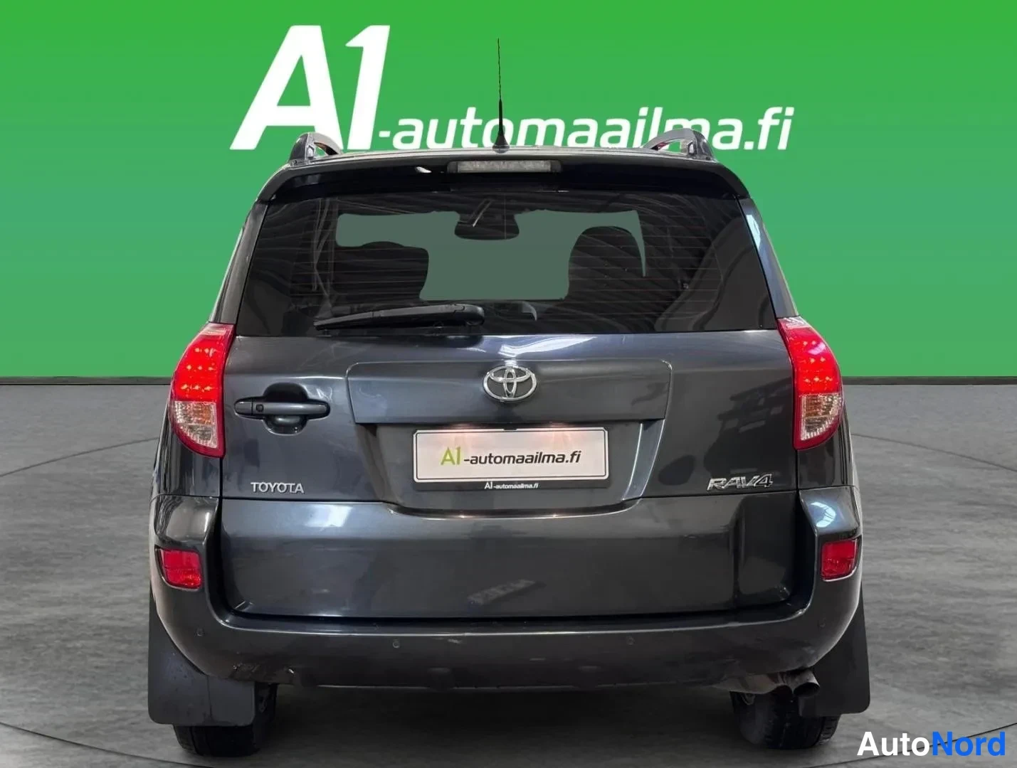 Takaa: Auton takaosa suoraan takaa: tummanharmaa Toyota RAV4, Toyota-merkintä ja RAV4-teksti takapuskurin molemmin puolin, A1-automaailma.fi-kilpi.