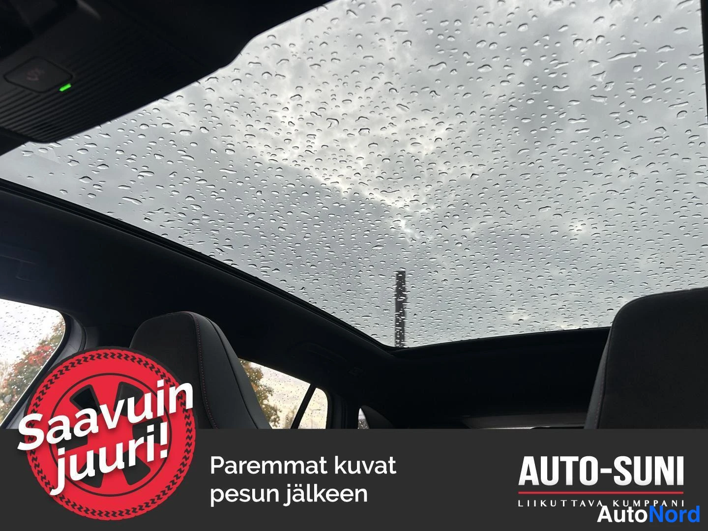Muu: Sisätilan yläosa: panoraamalasikatto, johon on satanut vesipisaroita, sateinen taivas ja tukena verhoilun reunaa.