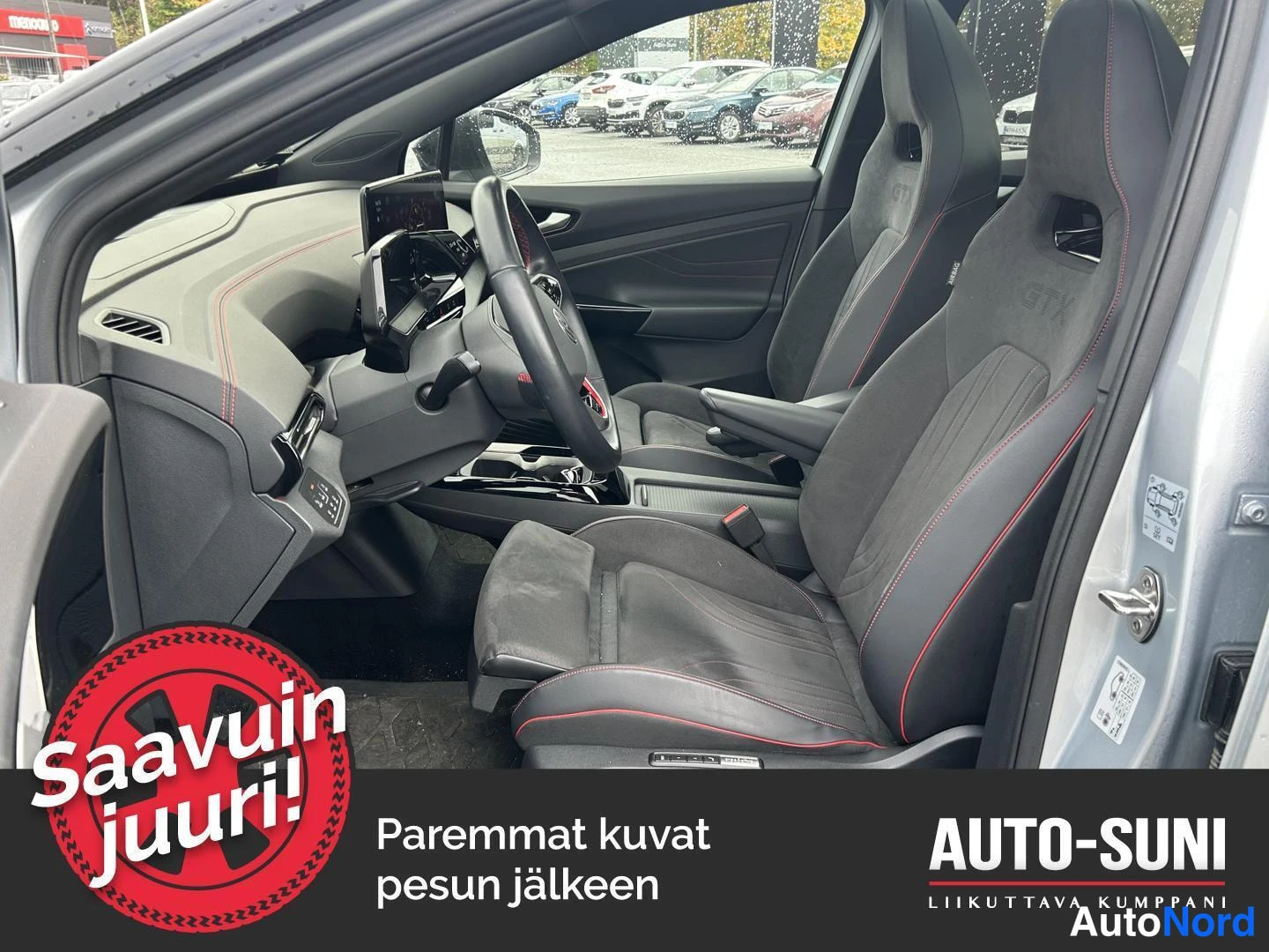 Muu: Volkswagen ID.4 GTX:n sisätilat: tummat urheiluistuimet punaisilla ompeluksilla, ohjauspyörä ja keskikonsoli.