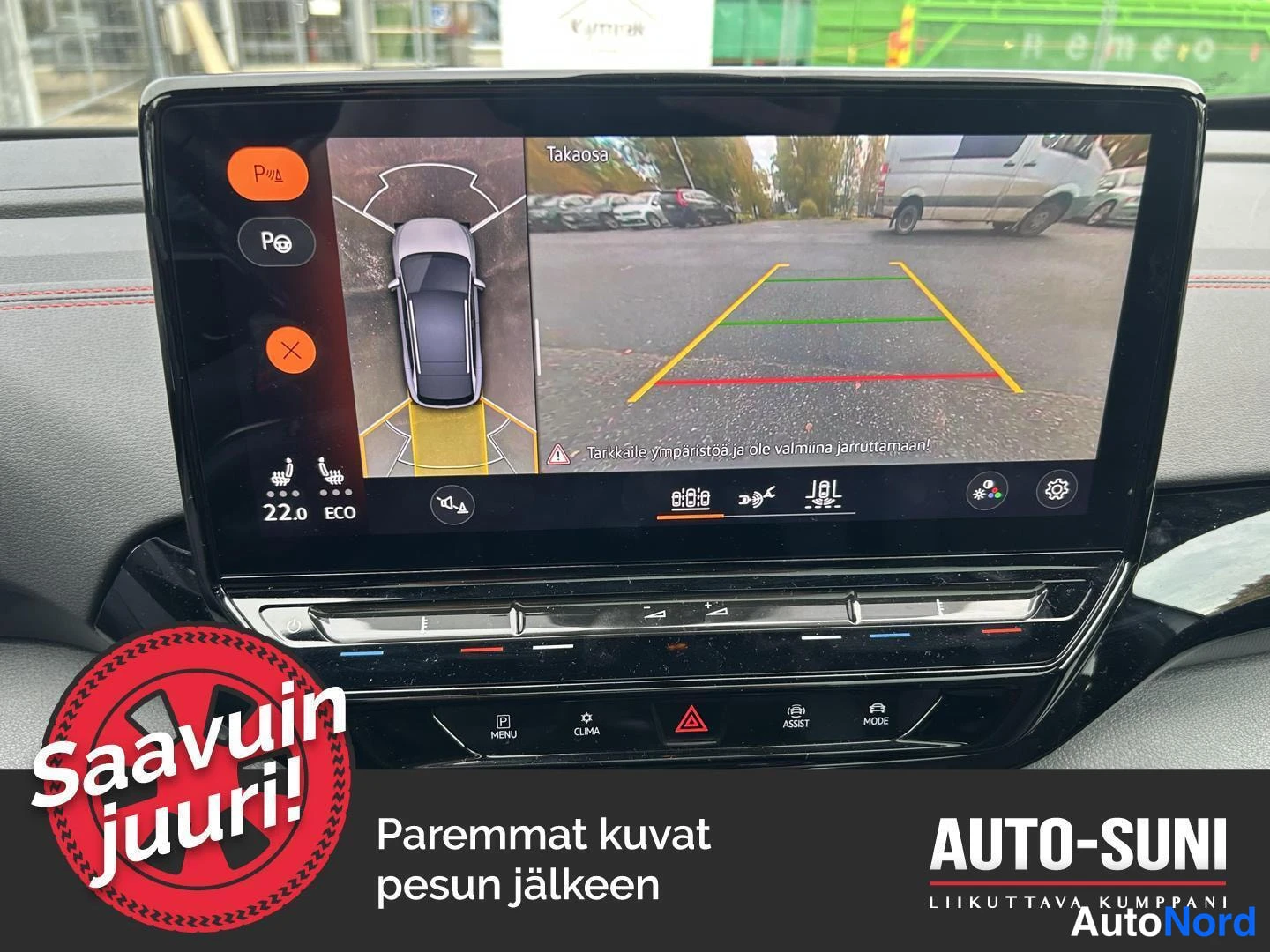 Muu: Kojelaudan näytöllä peruutuskameran kuva takana olevasta parkkipaikasta ja ympäristönäkymä, vihreä-kelta-punaiset etäisyysviivat.