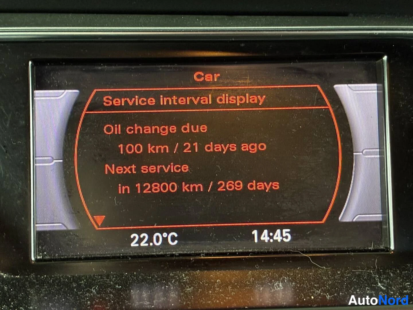 Muu: Kojelaudan näyttö, jossa Service interval display -ruutu: Oil change due 100 km / 21 days ago, Next service in 12800 km / 269 days, kulmassa 22.0°C ja 14:45.