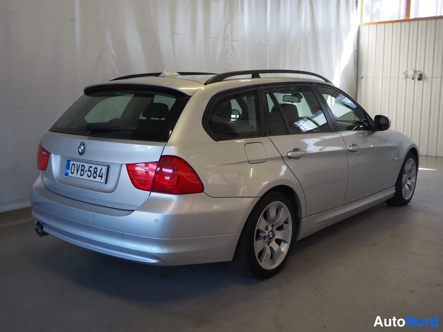 Takaviisto: BMW 318d Touring -farmari, takakulmasta vasemmalta, hopeinen, rekisteritunnus.