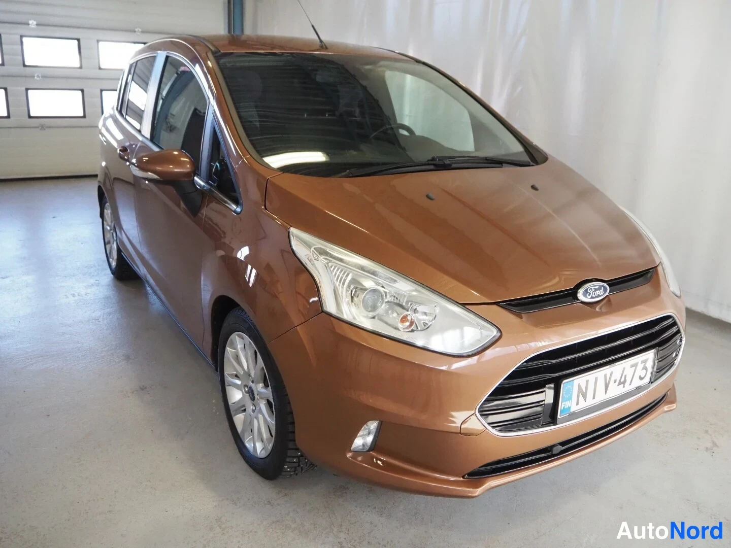 Etuviisto, nokka oikealle: Ford B-Max, etukolmixonäkymä oikealta, pronssinruskea kori, rekisteritunnus.