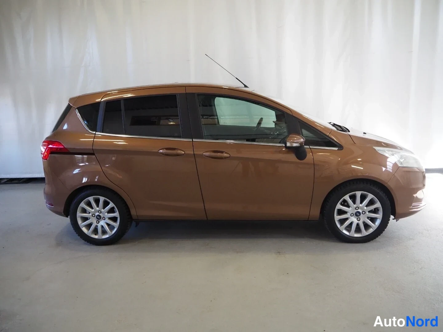 Etuviisto, nokka oikealle: Ford B-Max sivulta oikealta, pronssinruskea kori, kevytmetallivanteet, takana astinlusikka.