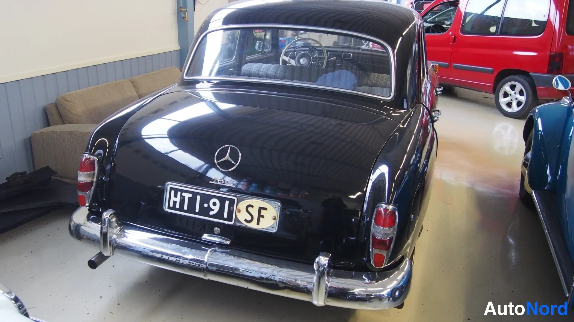 Takaa: Mercedes-Benz 180:n musta takaosa suoraan takaa; kromipuskurit, Mercedes-tähti ja rekisterikilpi SF-merkinnällä.