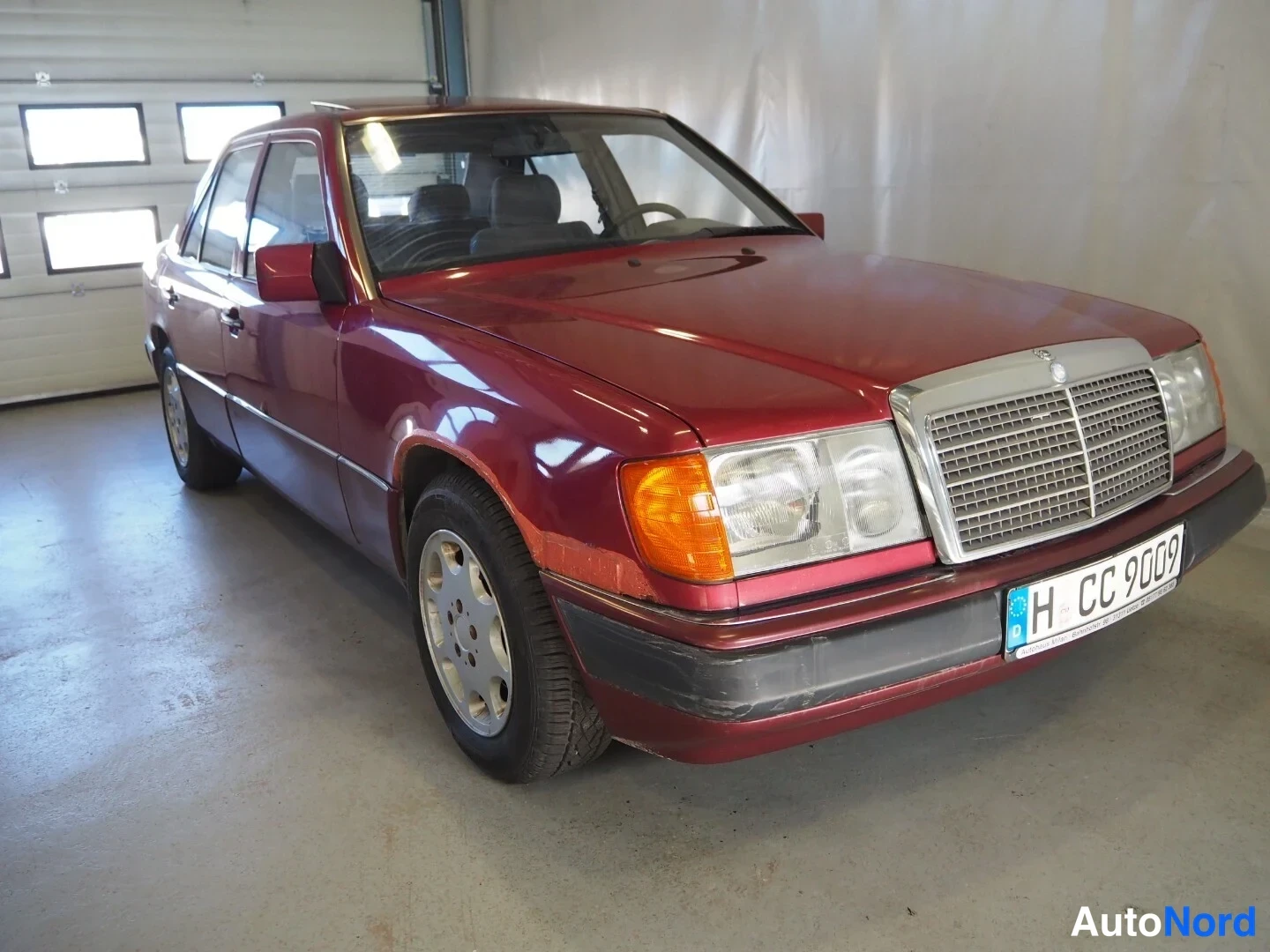 Etuviisto, nokka oikealle: Punaisen Mercedes-Benzin etukolmannes: kattila 'H CC 9009' ja peilattu merkki, konepellillä näkyy muutamia naarmuja.