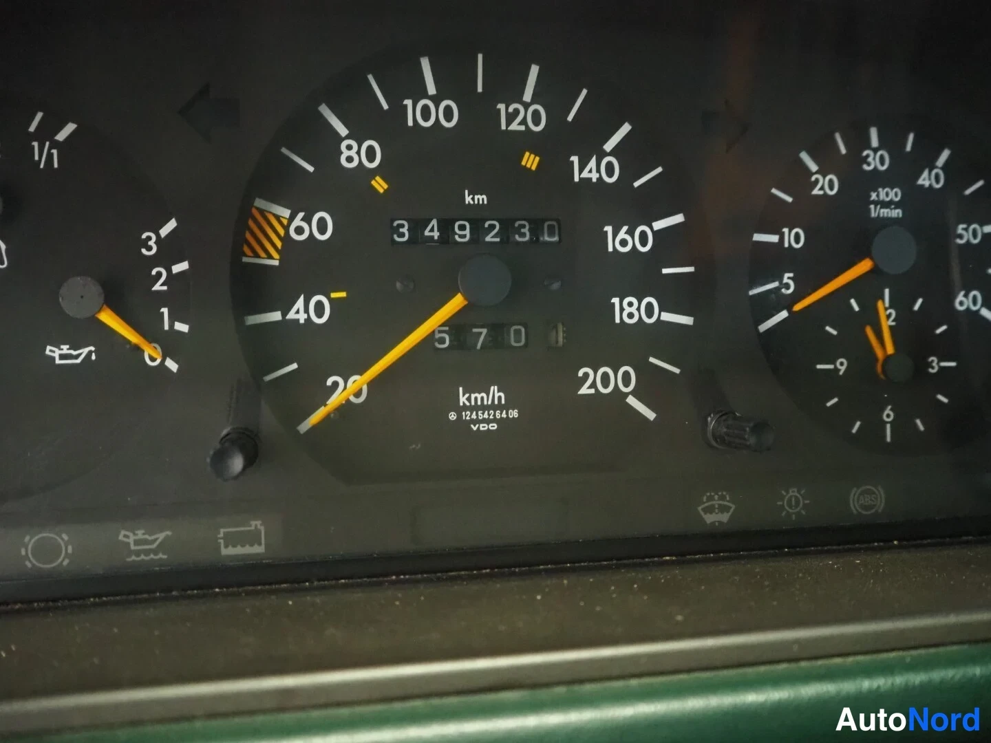 Yksityiskohta: Lähikuva auton mittaristosta. Nopeusmittari näyttää 349230 km kulkema matkamittarin lukemana ja pienempi osamittari 5701. Kellertävässä ilmanvaihtoventtiilin me