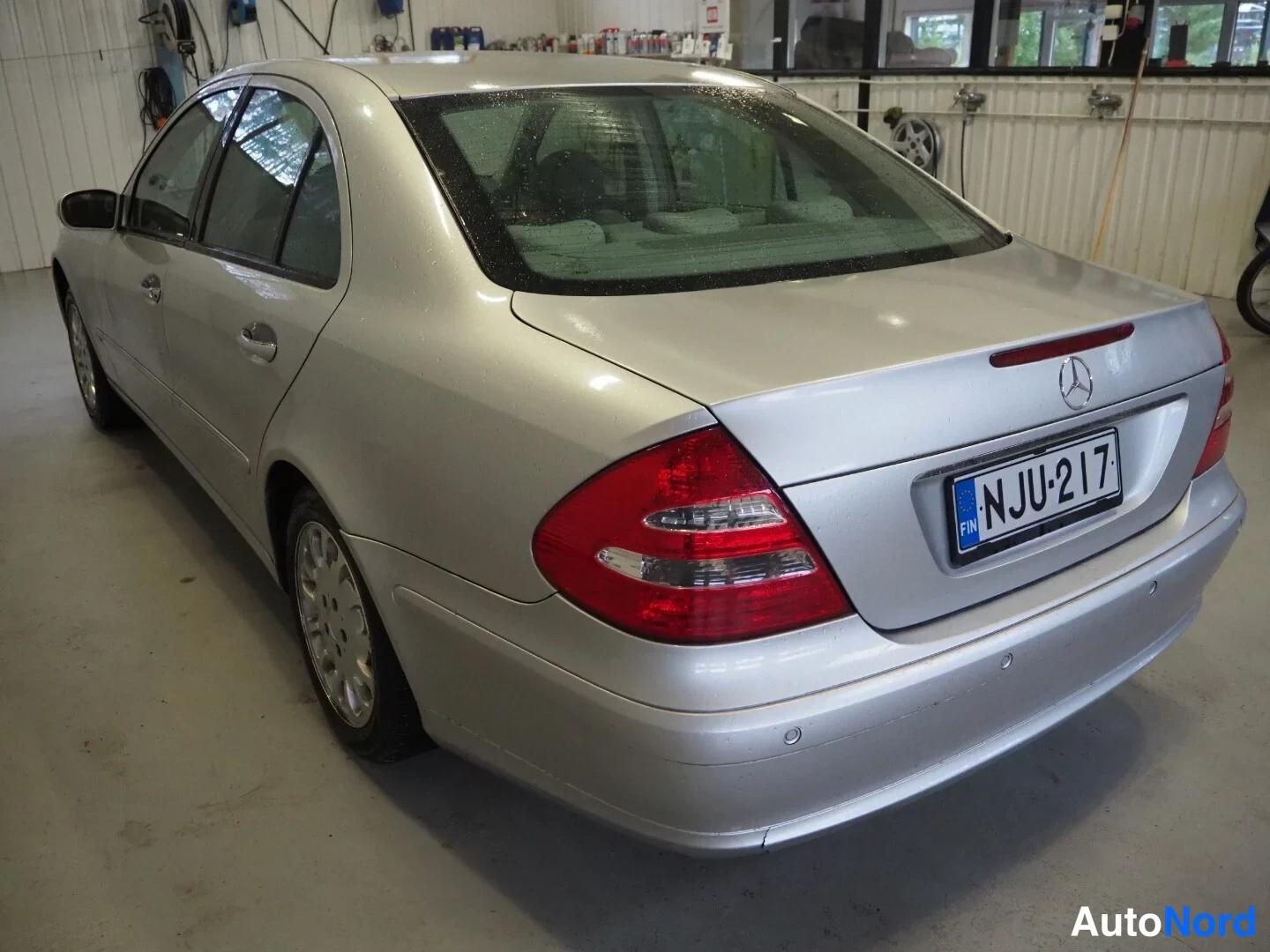 Takaviisto: Hopeinen Mercedes-Benz sedan takaviistöstä oikealta, rekisteritunnus.