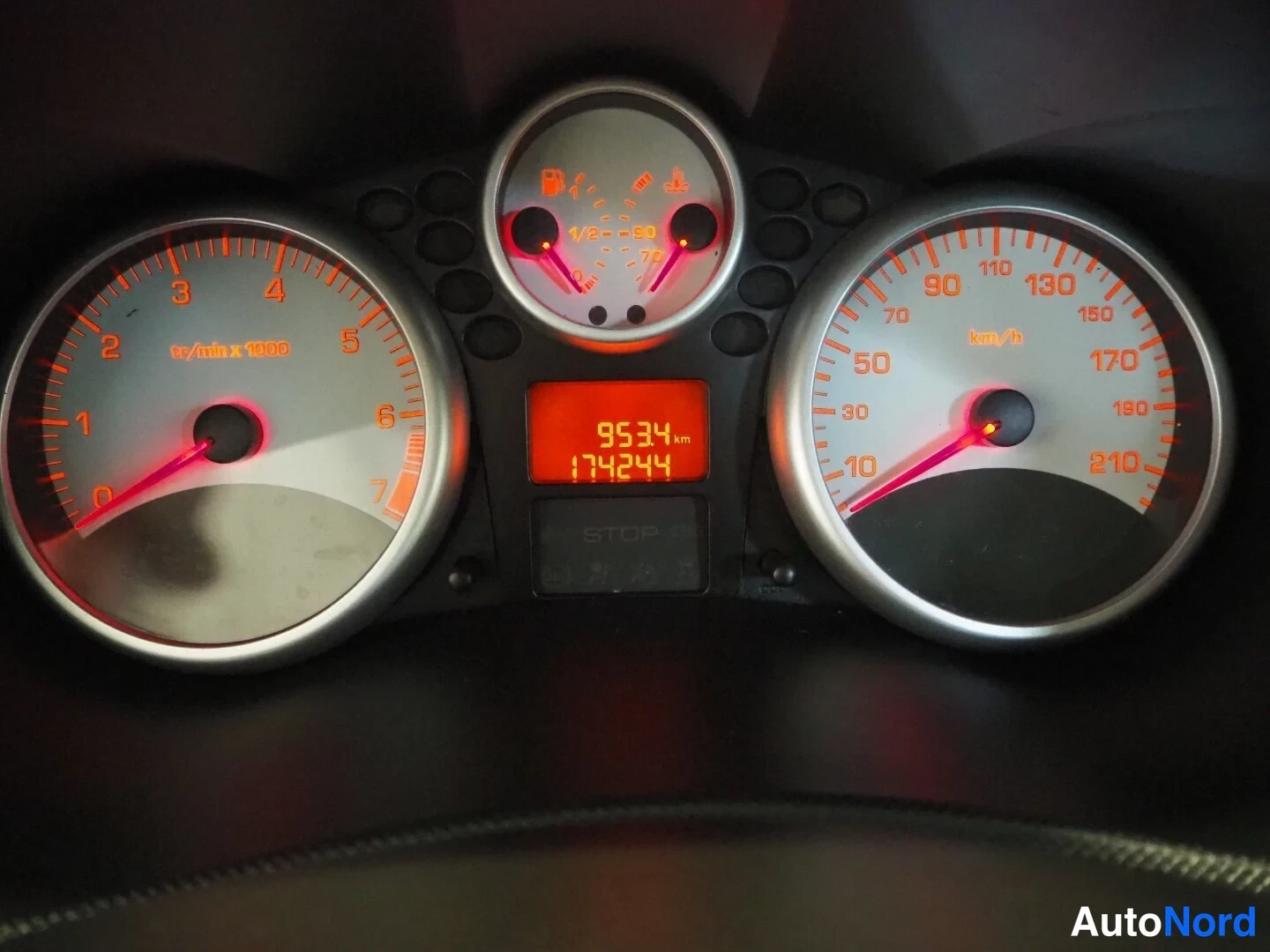 Muu: Peugeot 206:n kojelaudan mittaristo: takometri, nopeusmittari ja keskinäytössä kilometrilukema 174244 km sekä matkalaskuri 9534 km.
