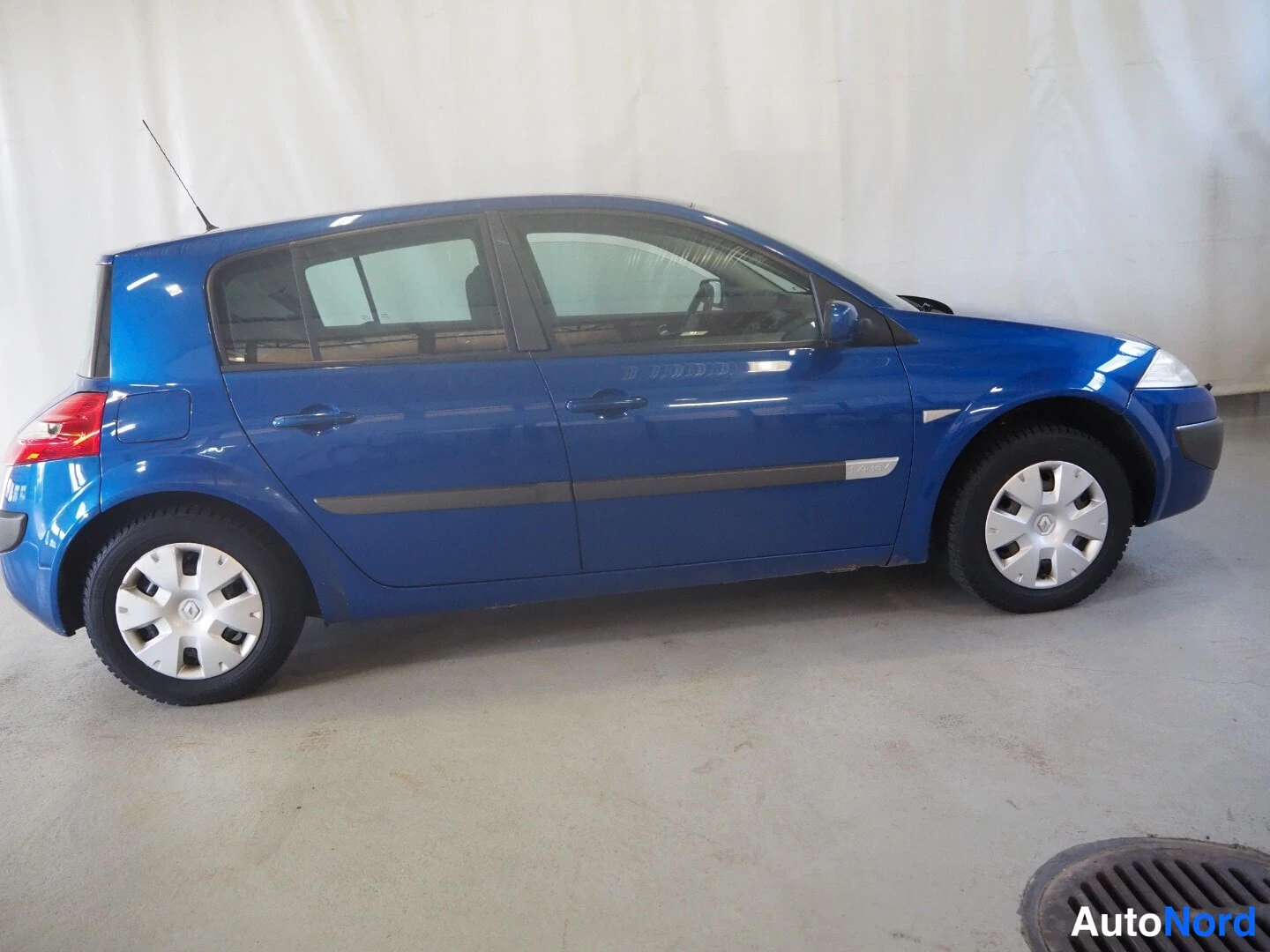 Sivulta: Sininen viisiovinen hatchback auton sivuprofiilista oikealta.