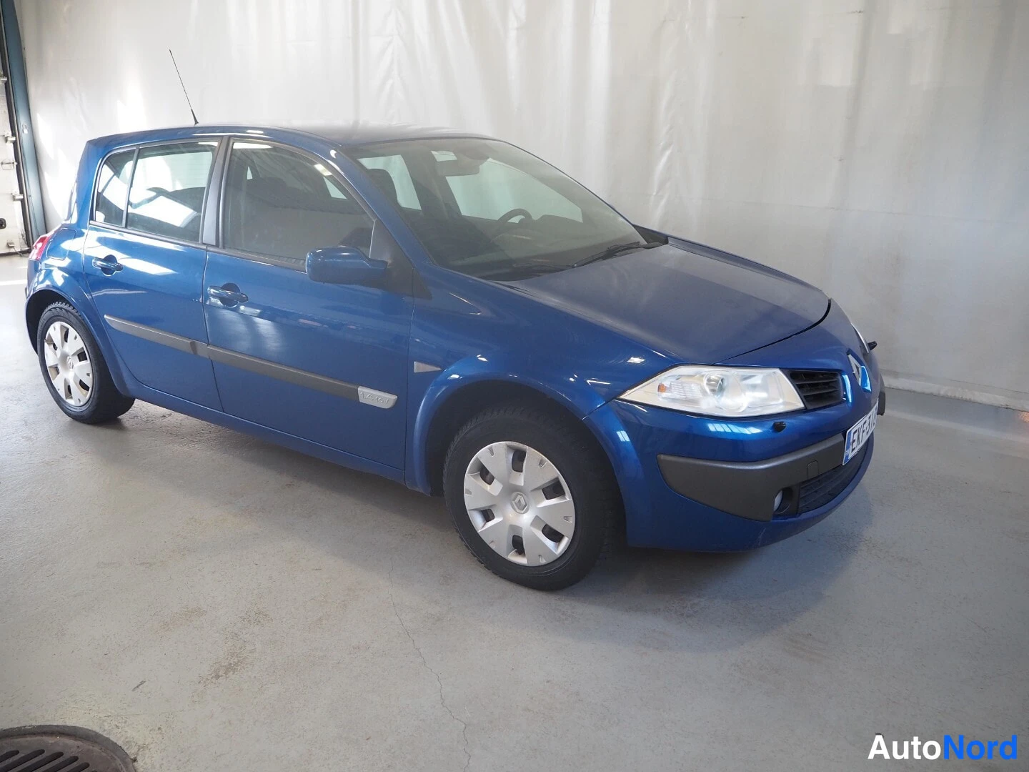 Etuviisto, nokka oikealle: Sininen viisiovinen hatchback etukulmasta oikealta talvirenkailla.