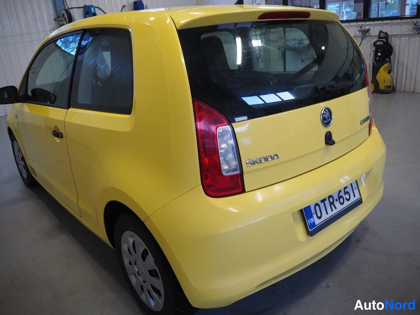 Takaviisto: Keltainen Skoda Citigo -viistoperä takaa-vasemmalta kuvattuna, rekisterikilpi.