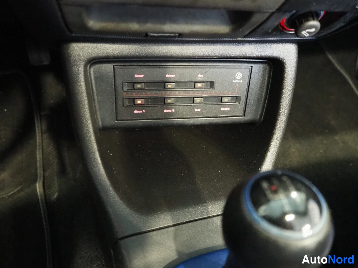 Yksityiskohta: Keskiyöhykkeen近kuva: Nokia-autoradio?, ei - Nokia-tason VWeen upotettu levysoitin? Kahdeksan painiketta merkitty teksteillä linear, driver, dyn, disc 1, disc 2,
