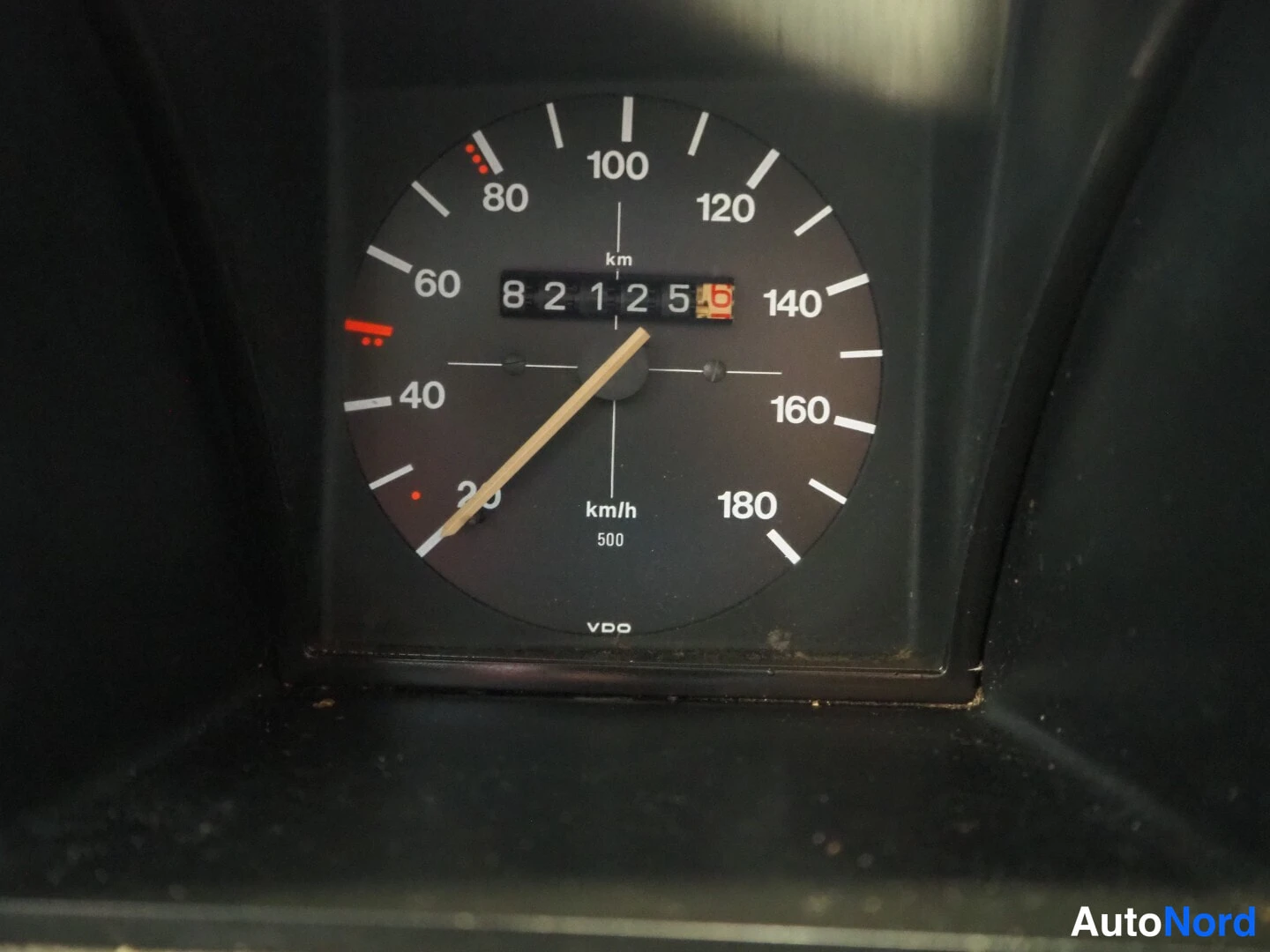 Muu: Nopeusmittari lähikuva, mittariasteikko 20-180 km/h, matkamittari näyttää 82125, merkintä VDO.