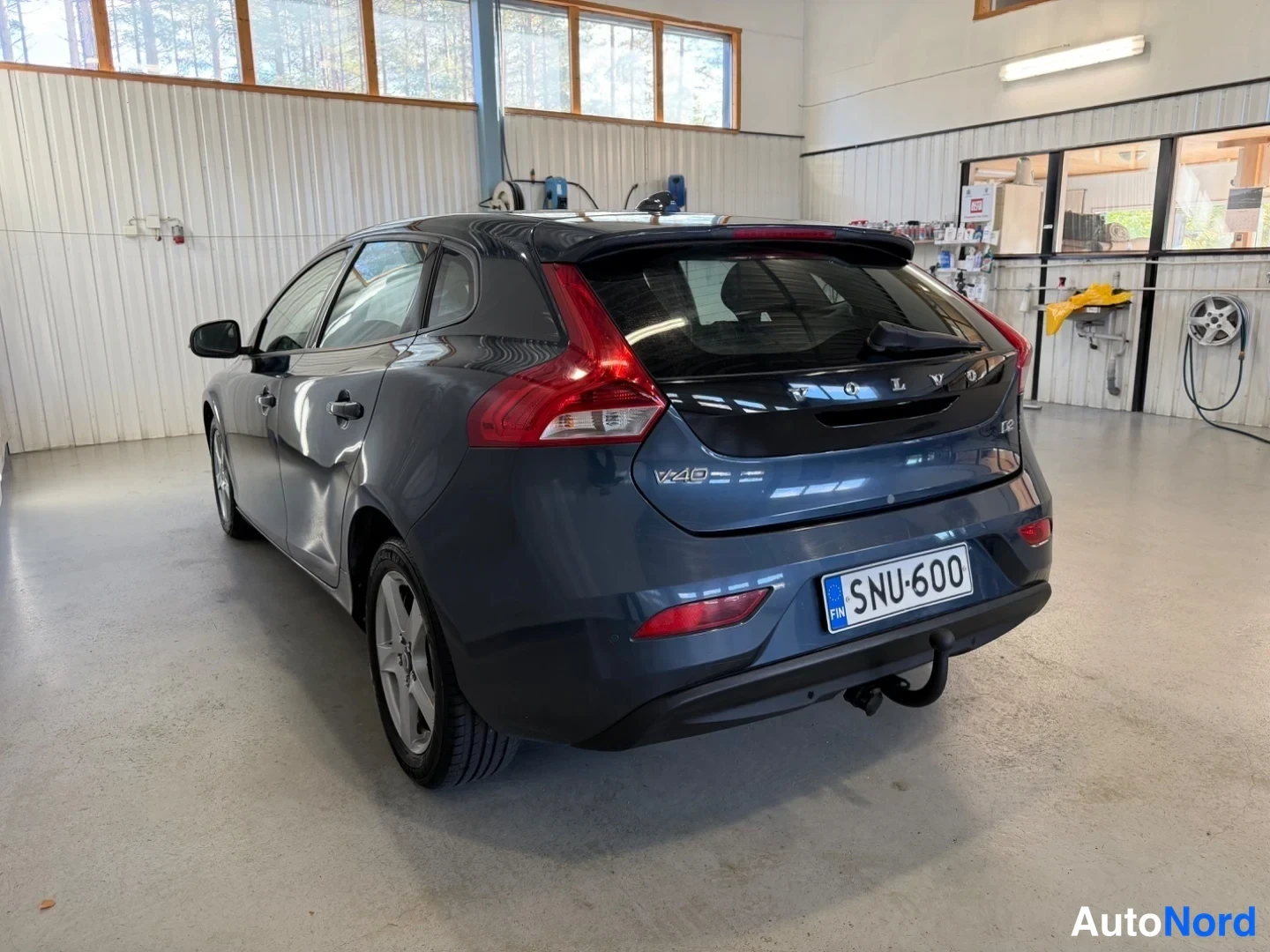 Takaviisto: Volvo V40 -henkilöauto takakulmasta vasemmalta, V40-merkintä takaluukussa, rekisterikilpi, vetokoukku takapuskurissa.