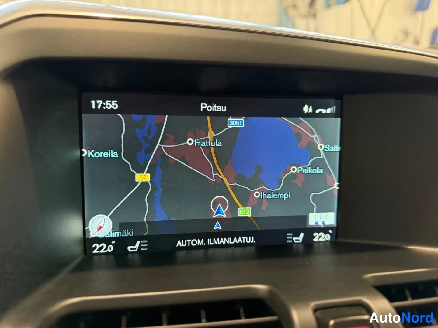Yksityiskohta: Keskikonsolin infotainment-näyttö näyttää karttanavigaatiota ja tekstiä 'AUTOM. ILMANLAATUJ.'.