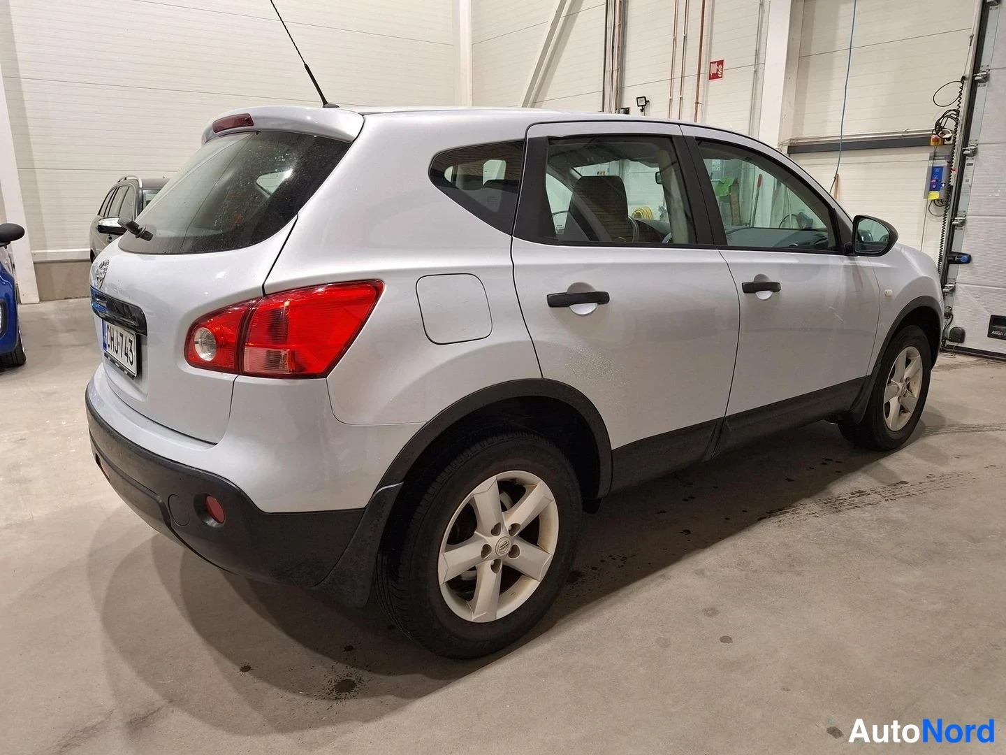 Takaviisto: Nissan Qashqain takakulma vasemmalta kuvattuna, punaiset takavalot ja rekisterikilpi näkyvissä.