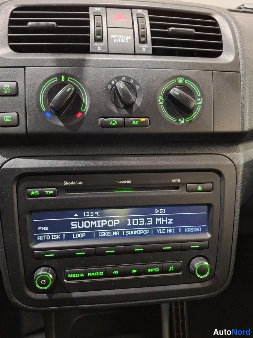 Yksityiskohta: Close-up of central console featuring climate control knobs, air vents and radio display
