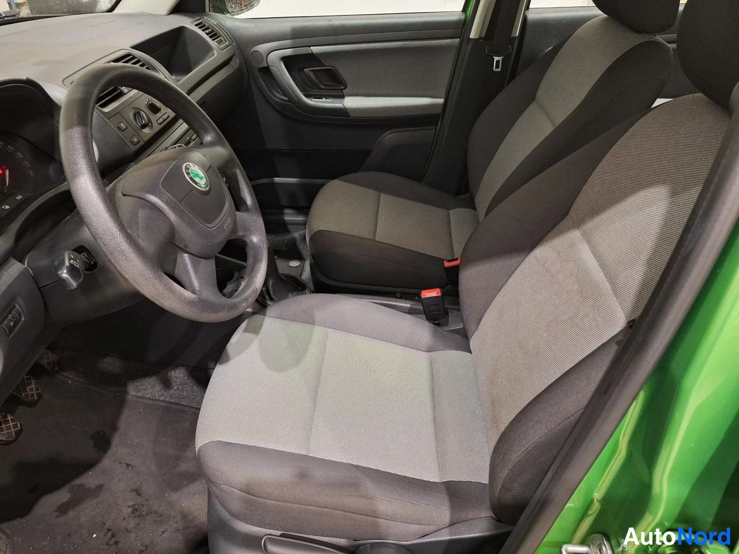 Etuistuimet: Cockpit view showing the steering wheel with Skoda logo and two front seats
