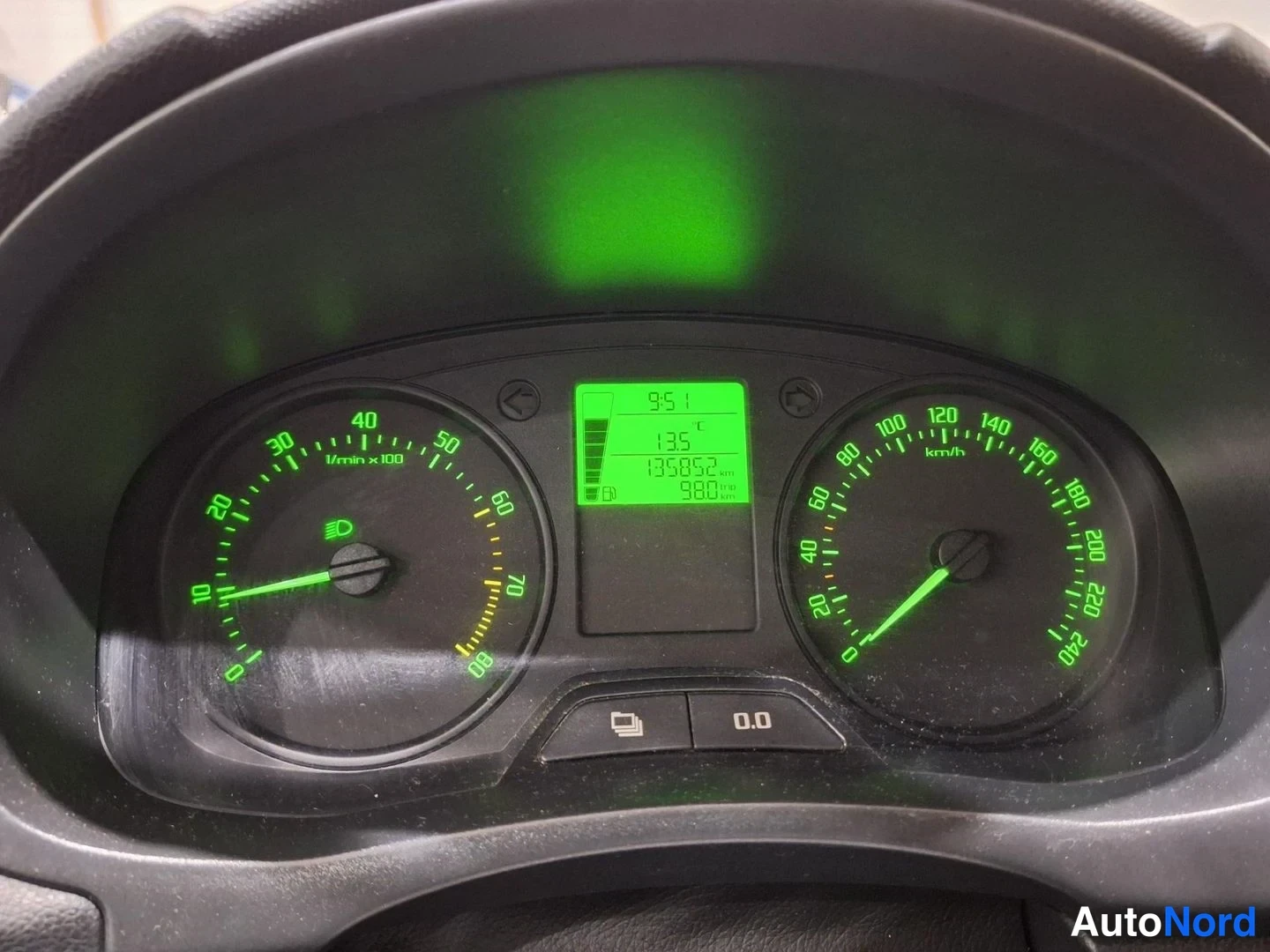 Yksityiskohta: Digital instrument cluster with green backlight showing odometer at 135852 km