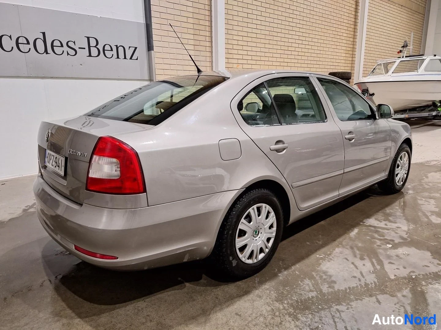 Takaviisto: Harmaanbeige Škoda Octavia -sedan takaosa kolmesta neljästä näkyvissä sisätilassa.