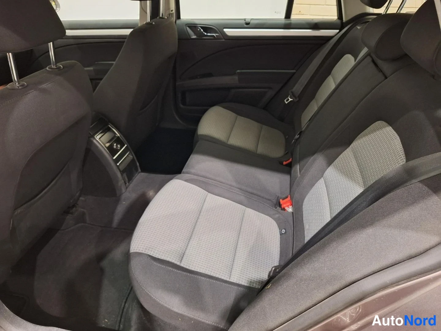 Takaa: Skoda Superbin takaistuin harmaa-mustalla kankaalla; keskikäsisija ja oven sisäpaneelet näkyvissä.