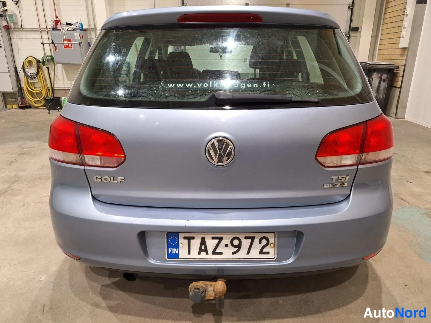 Takaa: Volkswagen Golf takaa kuvattuna; takaovessa merkinnät GOLF ja TSI BlueMotion, rekisterikilpi ja irrotettava vetokoukku puskurin alla.