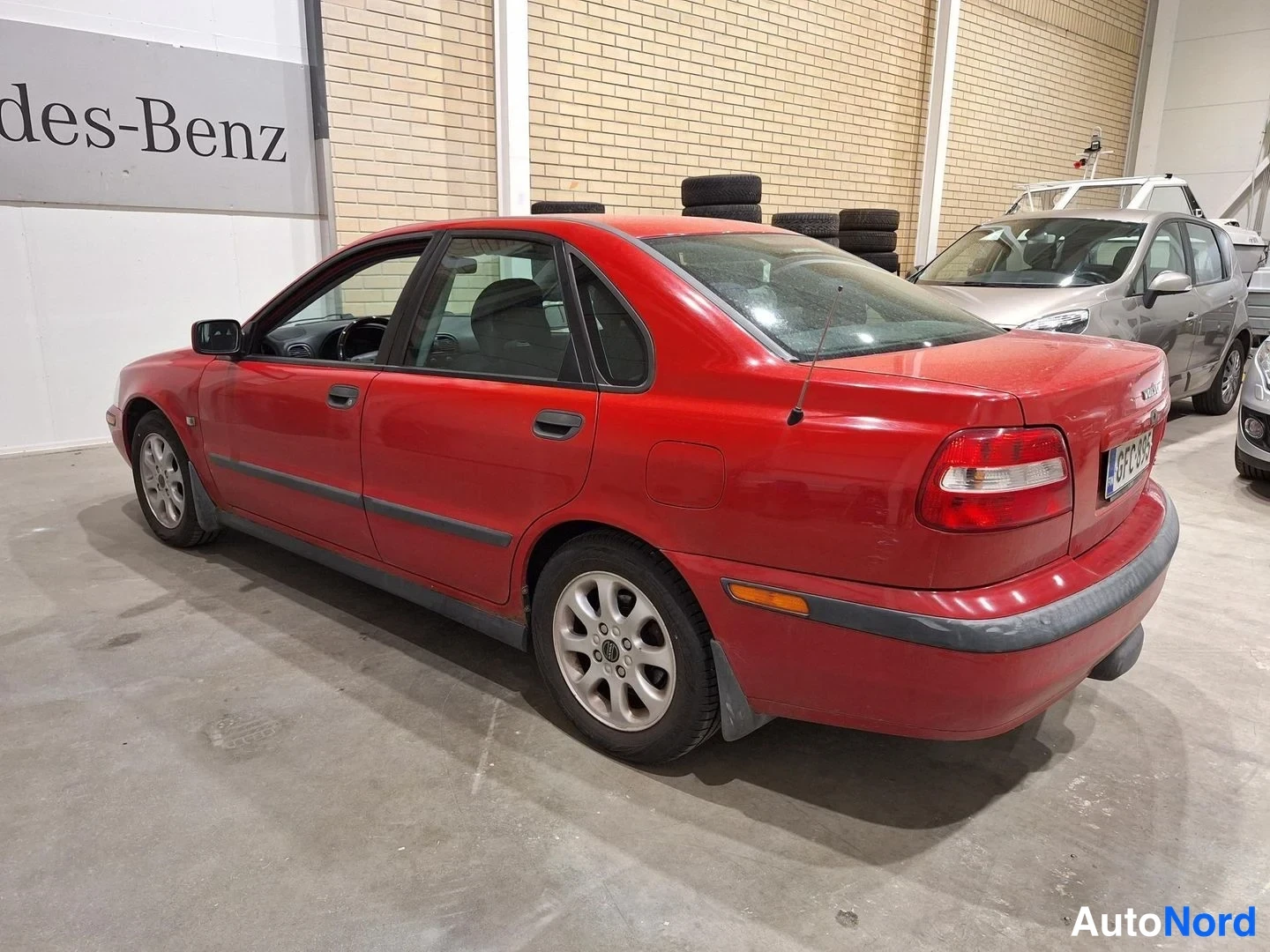 Takaviisto: Punainen Volvo S40 -sedan vasemmalta takaviistolta kuvattuna autotallissa.