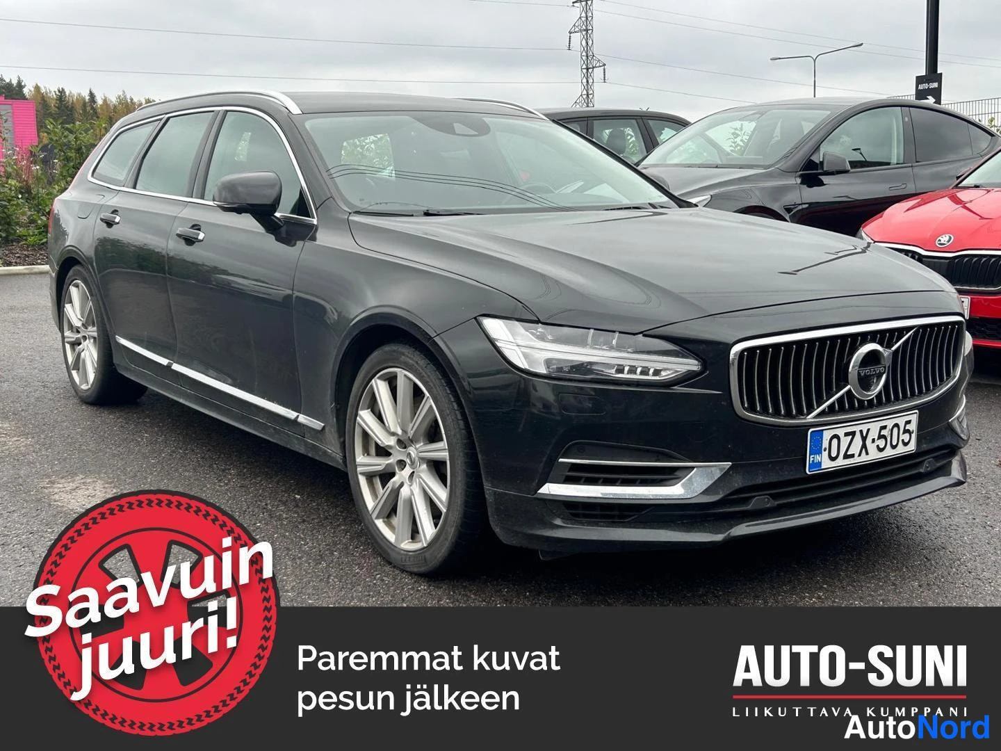 Etuviisto, nokka oikealle: Mustanharmaa Volvo V90 farmari kolme­neljäsosan etunäkymässä, keula oikealla, rekisterikilpi.