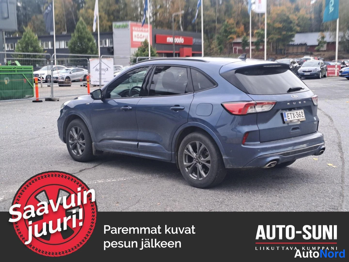 Takaviisto: Auton takanurkkaus, rekisterikilpi, takana tavaratilan kansi ja auki avattu takaosa.