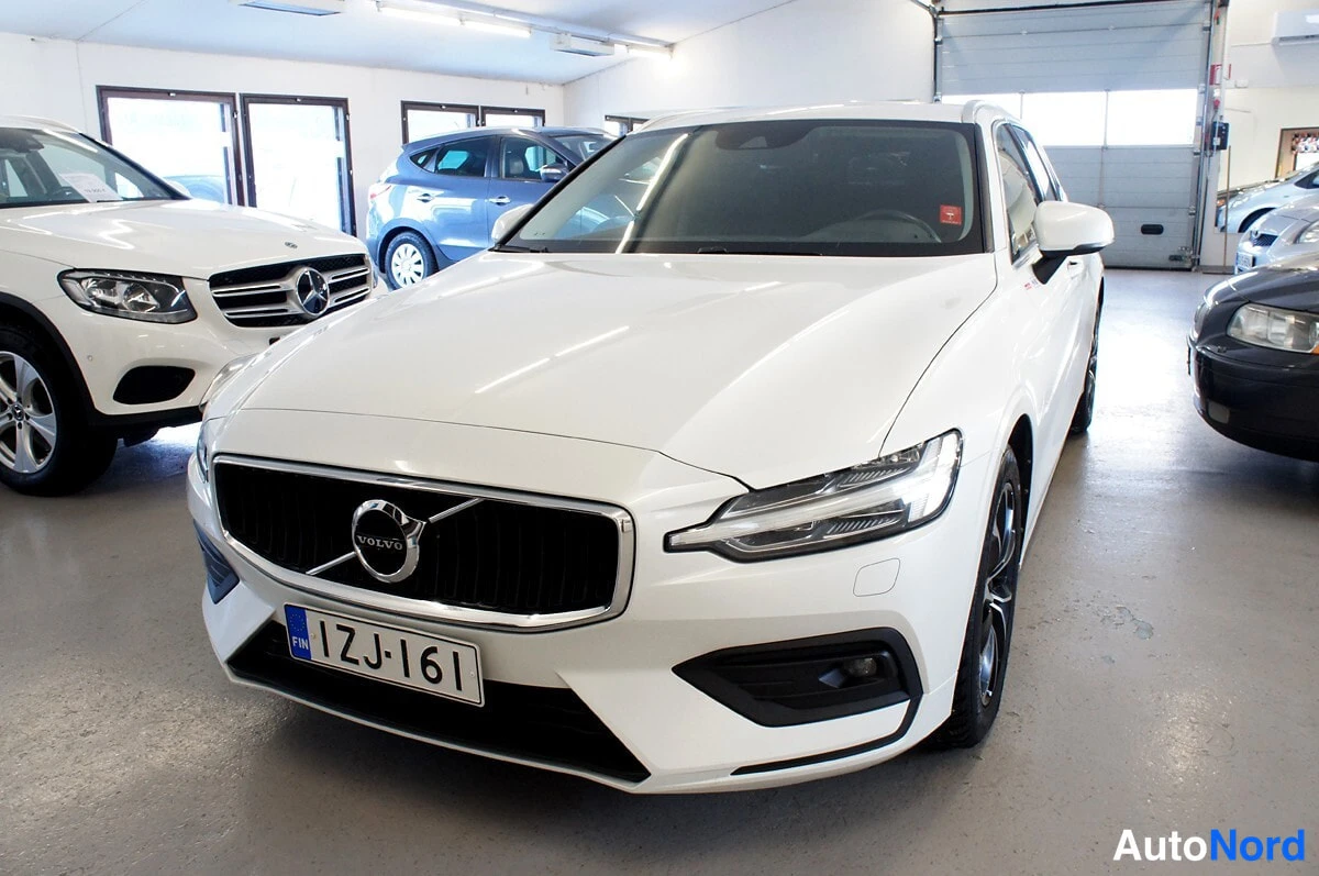 Etuviisto, nokka vasemmalle: Volvo V60 -farmarin keula lähikuvasta, valkoinen, etusäleikkö ja Volvo-tunus, rekisterikilpi.