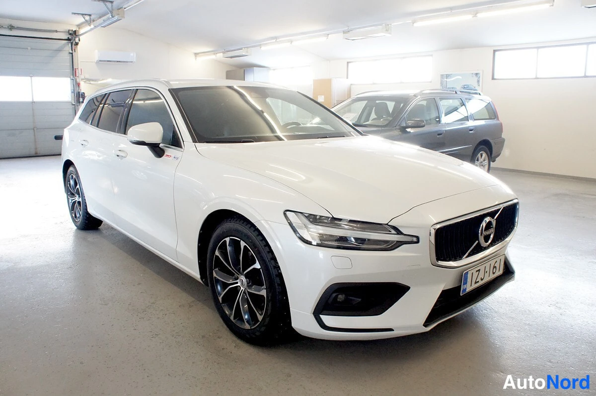 Etuviisto, nokka oikealle: Volvo V60 -farmari etuosa ja vasen kylki näkyvissä, valkoinen, rekisterikilpi.