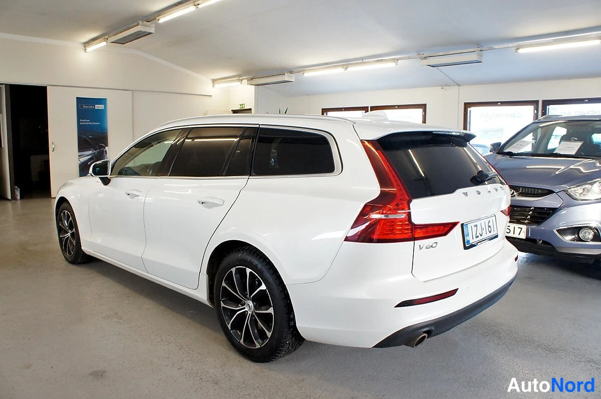 Takaviisto: Volvo V60 -farmarin takakulman takaa vasemmalta kuvattu valkoinen auto sisätiloissa.