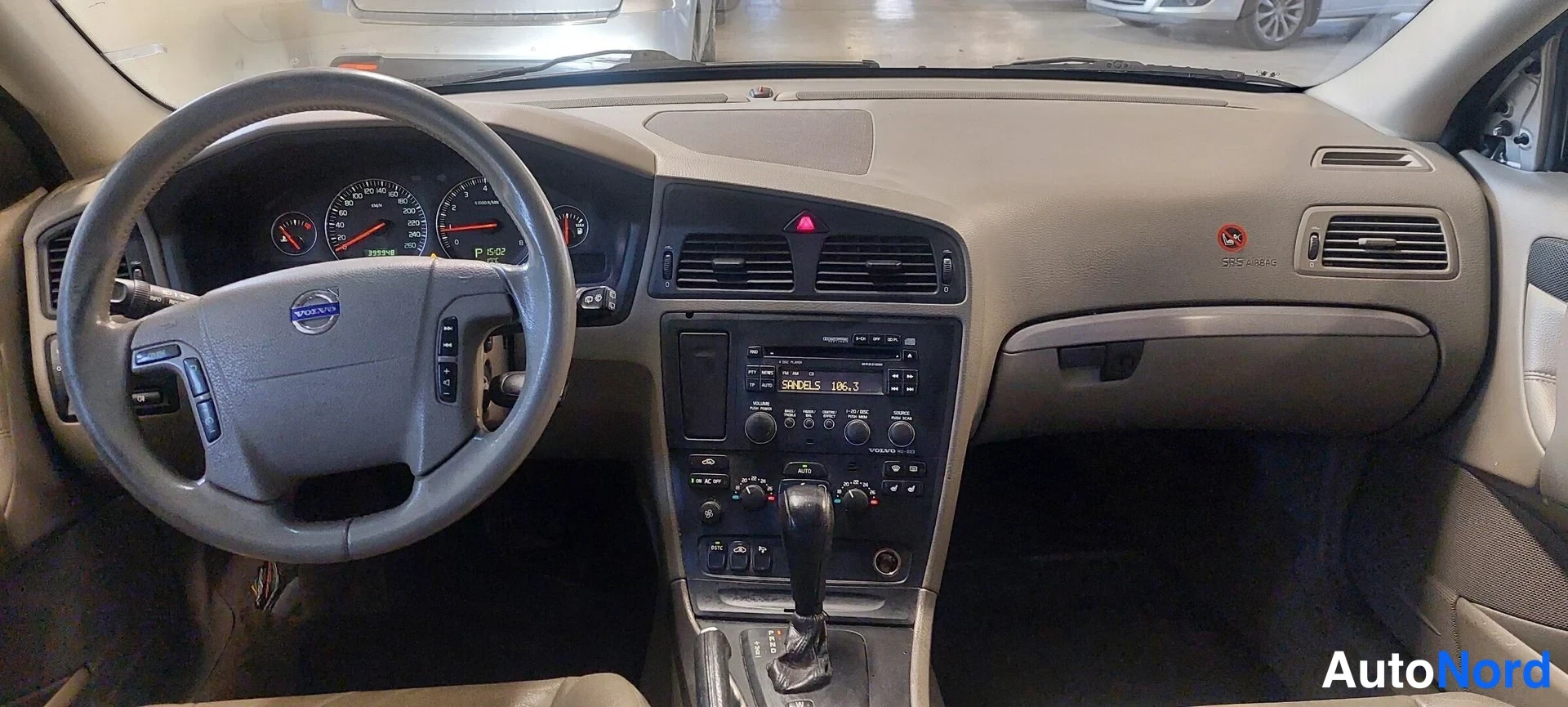 Muu: Ohjaamon näkymä Volvossa: ohjauspyörä, mittaristo, keskikonsoli ja radiopaneeli näkyvät.