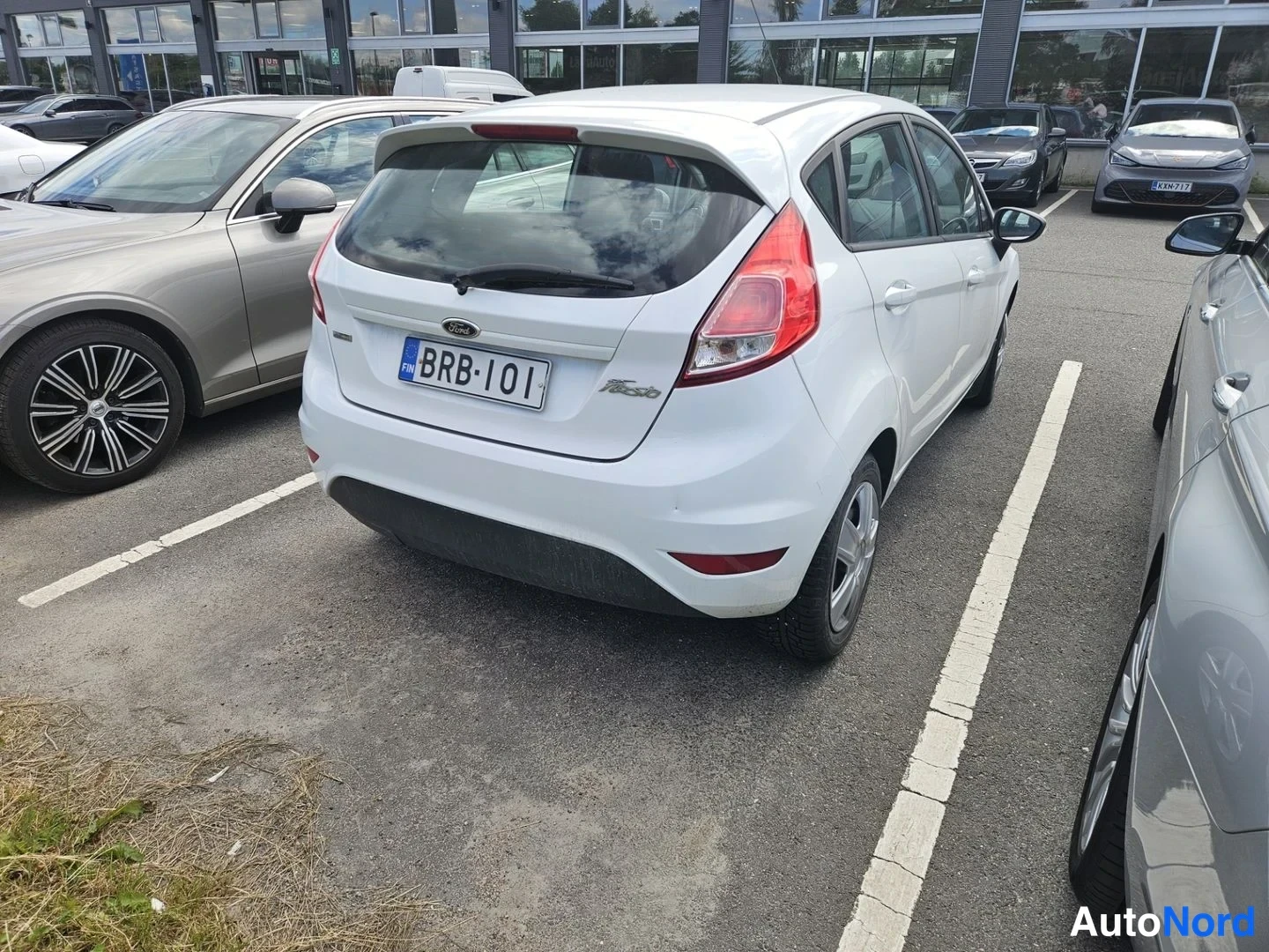 Takaviisto: Valkoinen Ford Fiesta takaa kolmasosan kulmasta, takavalot ja -kilpi näkyvissä.