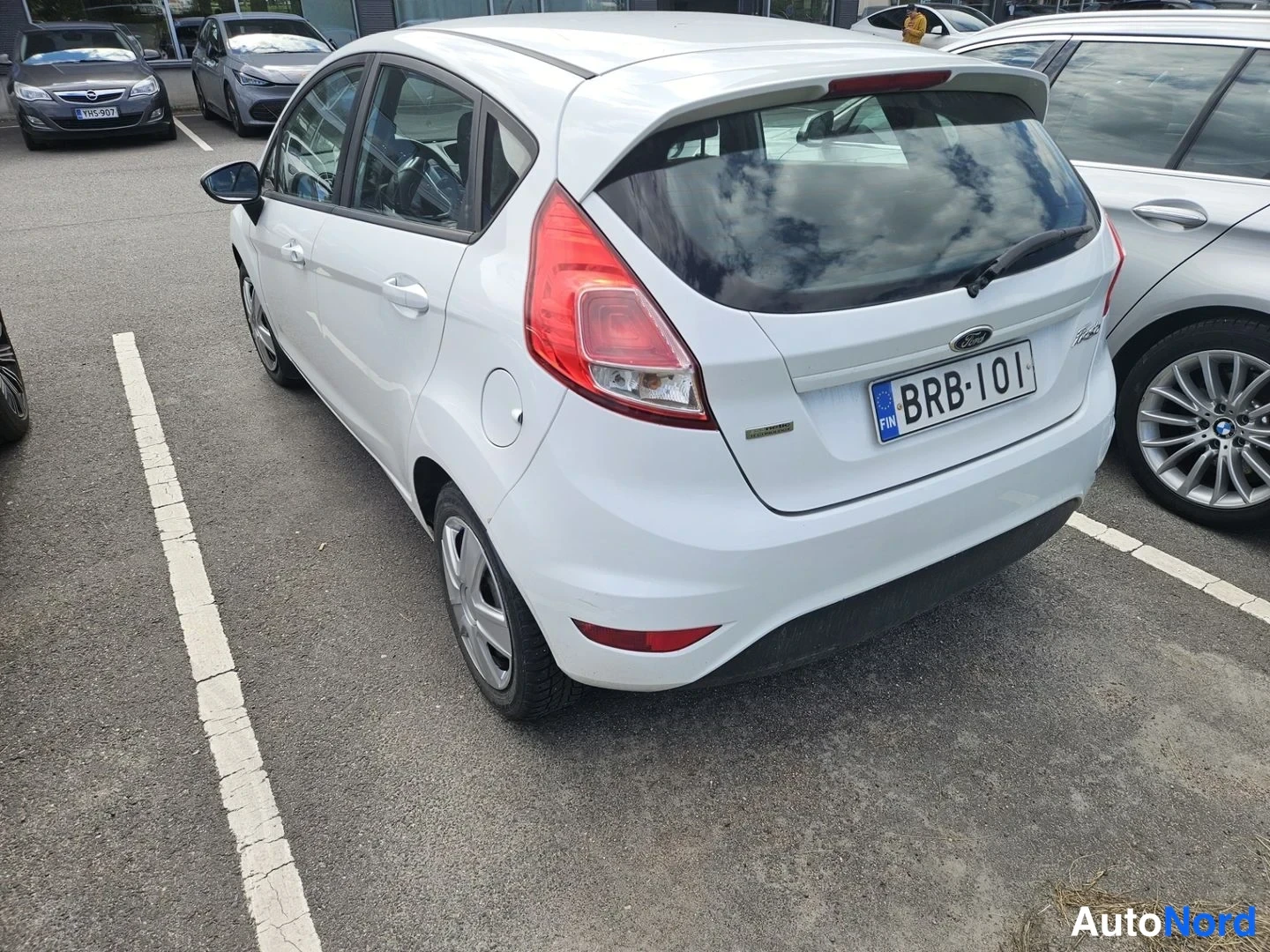 Takaviisto: Valkoinen Ford Fiesta takaa kolmasosan kulmasta, takaluukku ja -kilpi näkyvissä.