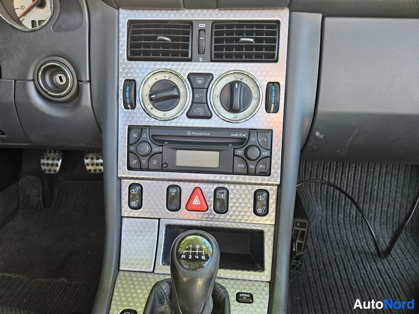 Muu: Sisätila: keskikonsolin painikkeet, Mercedes-Benz radio-CD-yksikkö ja 6-vaihteinen manuaalivaihteen kytkinpallo.