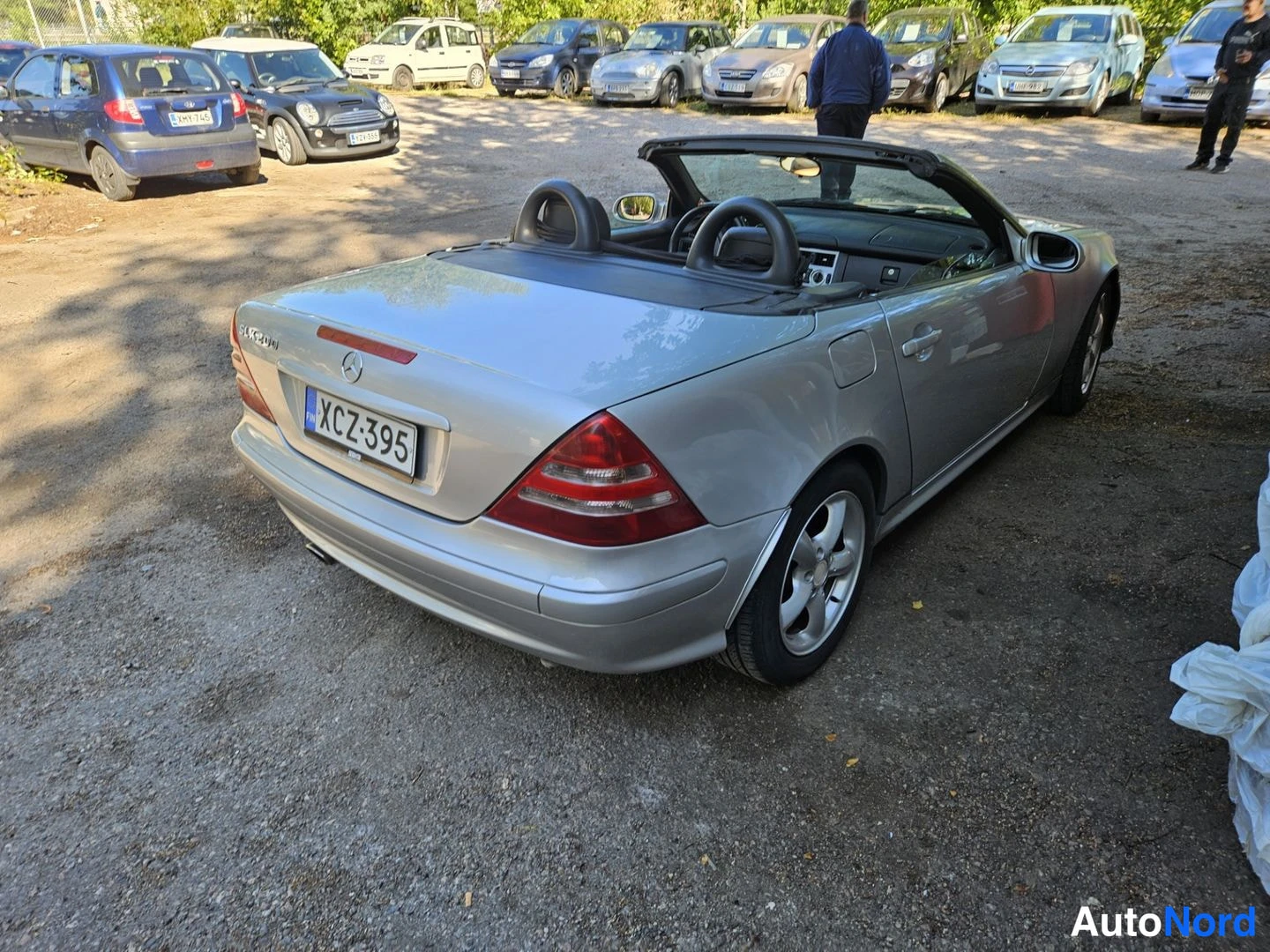 Takaviisto: Hopeanvärinen avokattoinen Mercedes SLK avokatto auki, takakulmasta vasemmalta, rekisteritunnus.